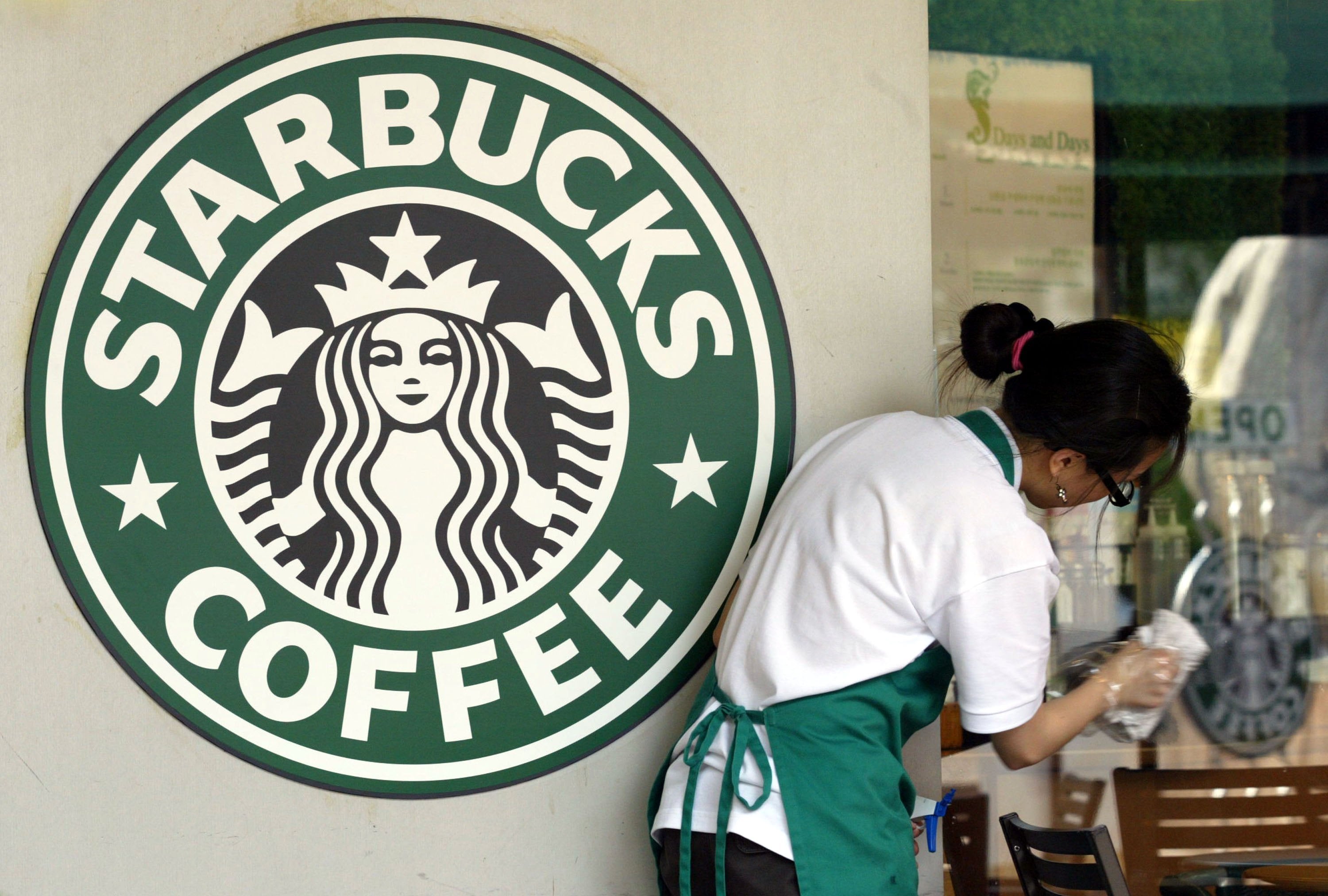 <p>File. Starbucks worker cleans a shop window in Seoul, South Korea</p>