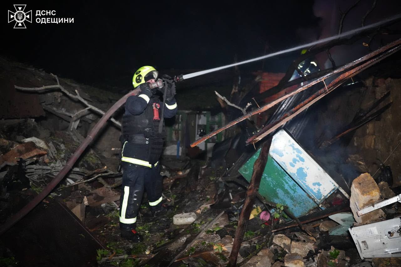 A rescue worker puts out a fire of a building damaged after a Russian strike on Odesa