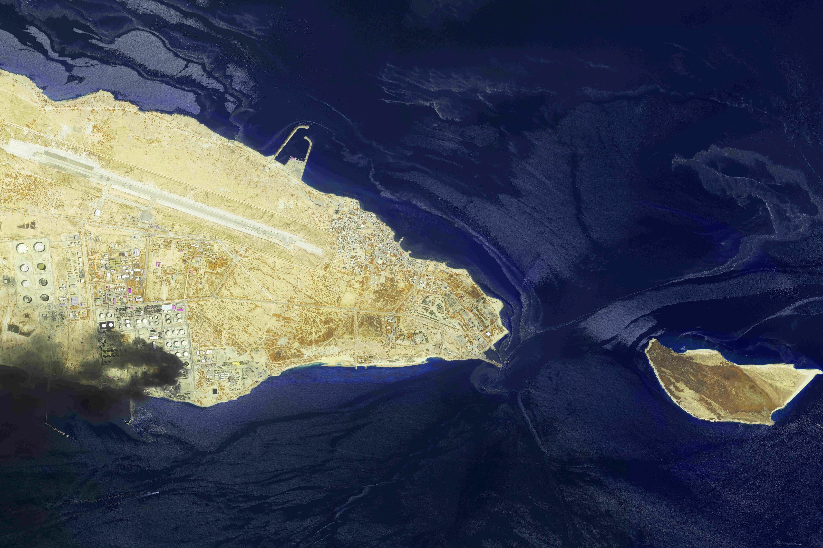 This image from an Airbus Defence and Space's Pléiades Neo satellite shows a fire at an oil refinery on Iran’s Lavan Island, left, and an oil slick in the waters of the Persian Gulf around Shidvar Island (AP)