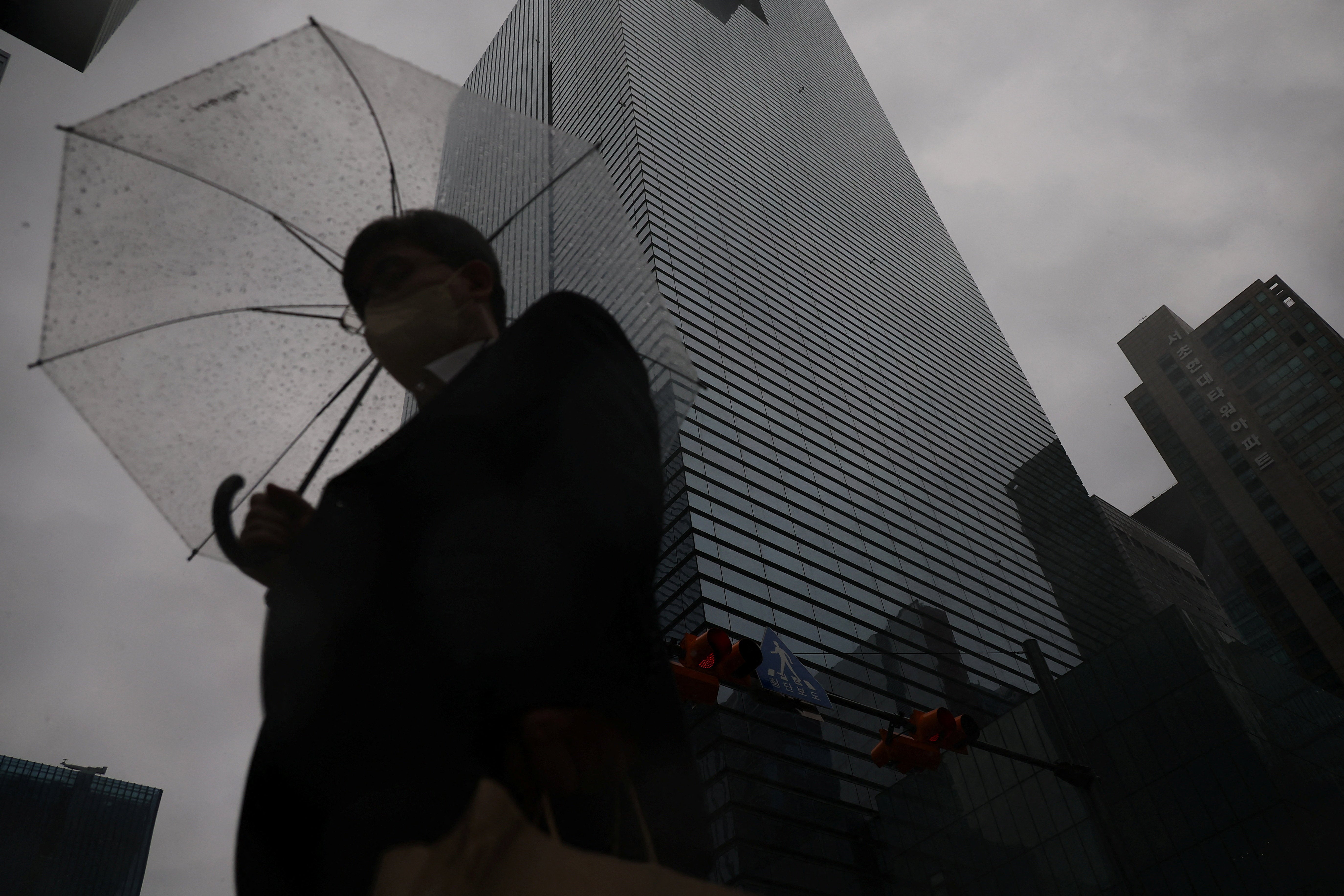An employee holding an umbrella walks in front of Samsung Electronics office building as it rains in Seoul, South Korea, May 20, 2026. REUTERS/Kim Hong-Ji
