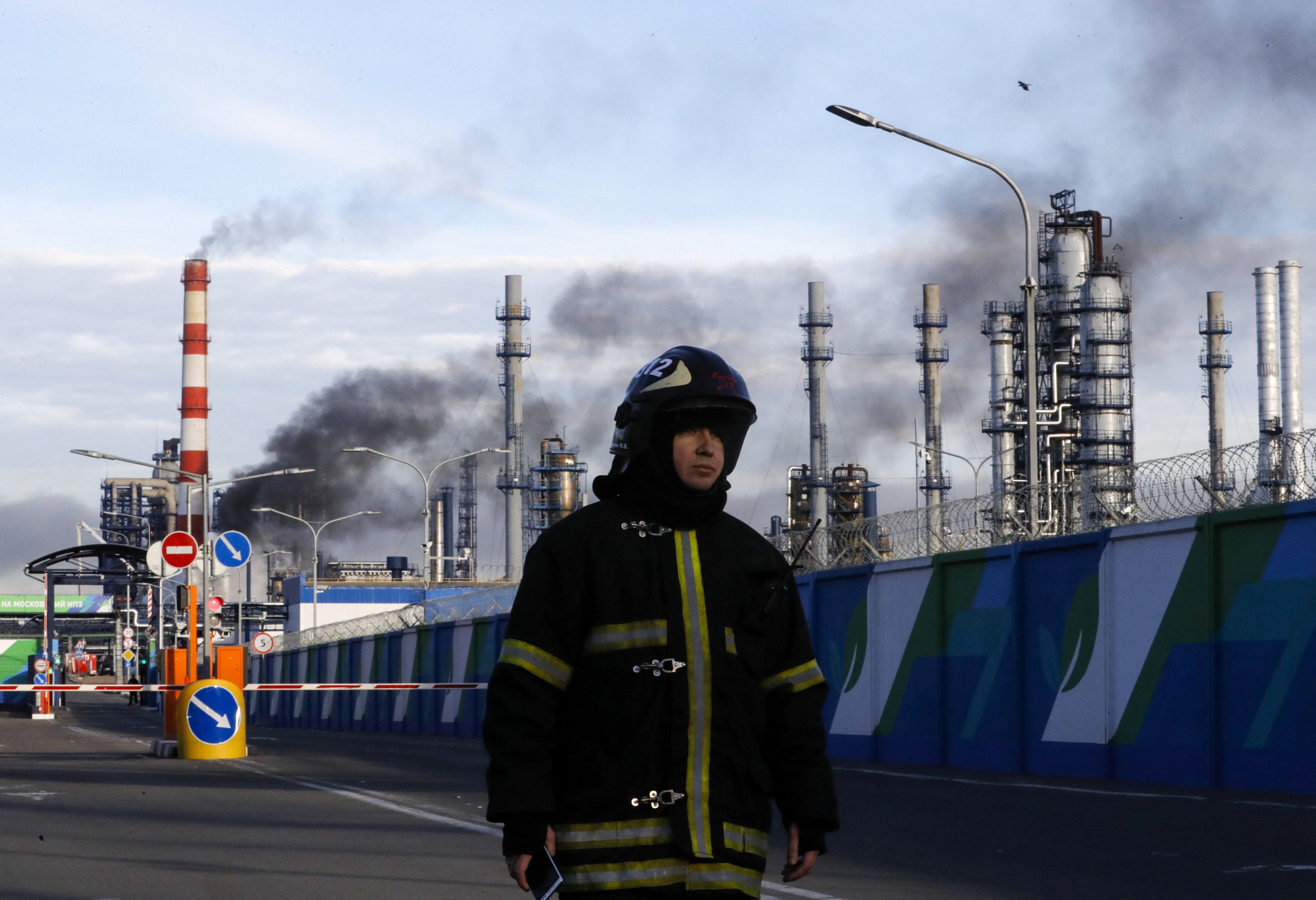 A firefighter is seen on a site, as smoke billows from a fire at oil refinery, owned by Russian oil producer Gazprom Neft, in Moscow