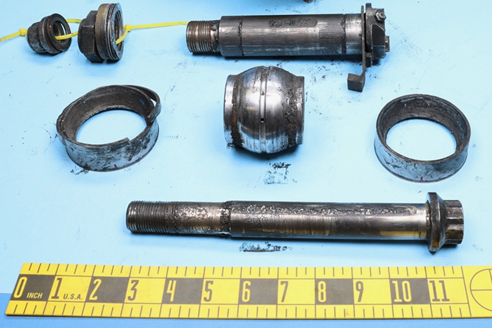 This photo released by the National Transportation Safety Board (NTSB) on Nov. 20, 2025, shows the spherical bearing and other pieces of the damaged mount of the engine