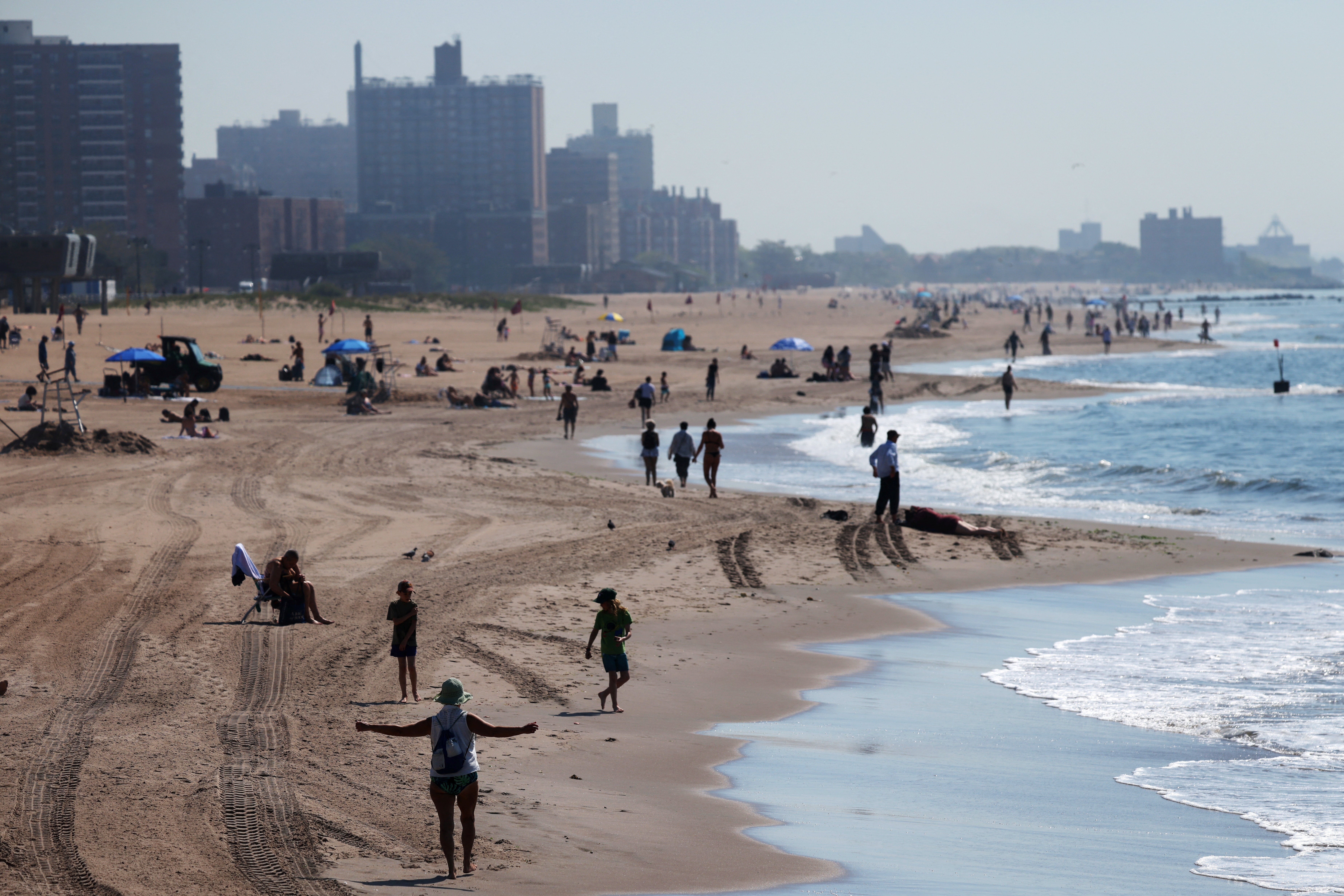 People gather on the beach at Coney Island in the Brooklyn borough of New York