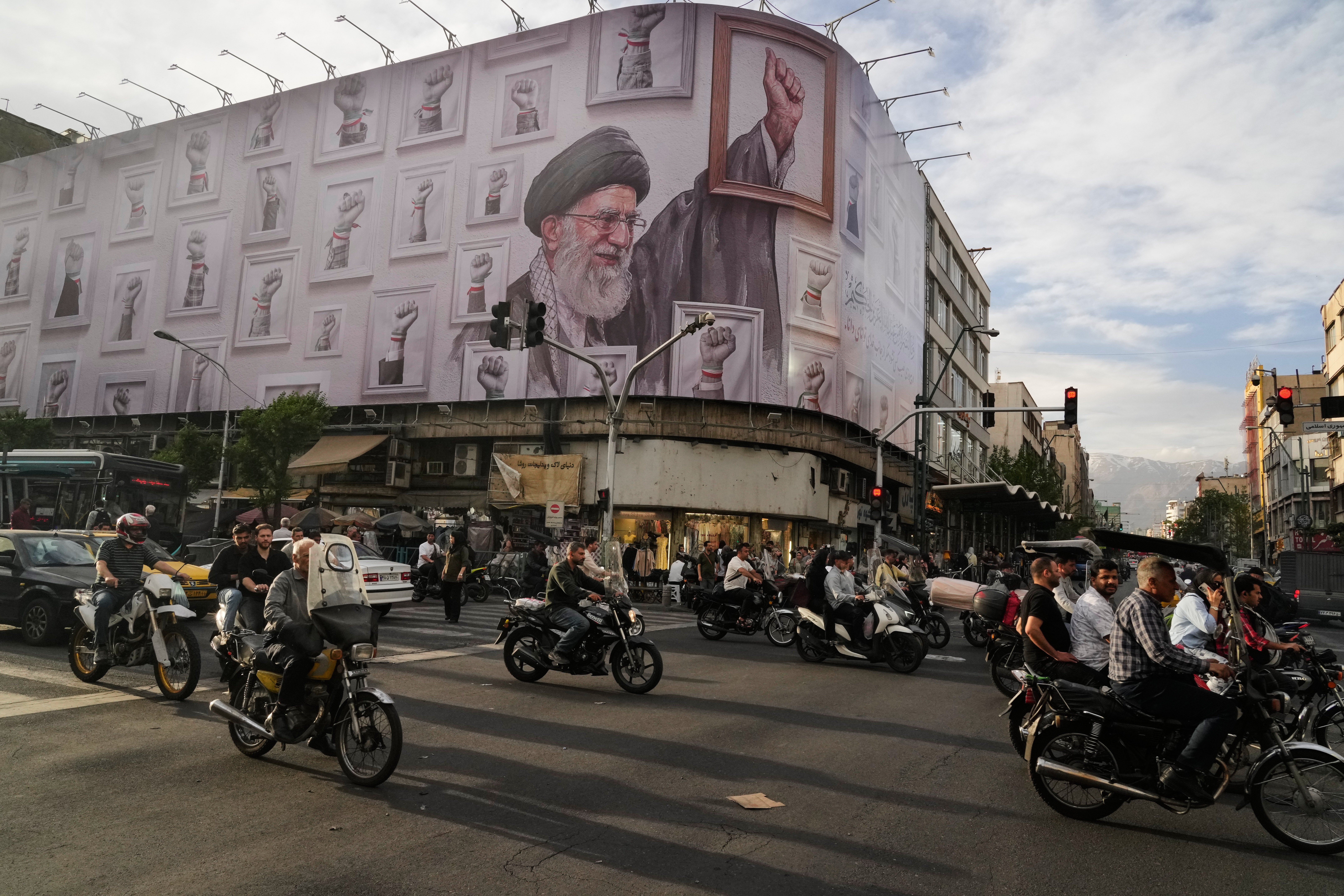 Motorbikes drive past a billboard showing the late Iranian Supreme Leader Ayatollah Ali Khamenei, who was killed in the U.S. and Israel strikes on Feb. 28, in downtown Tehran, Iran, May 6, 2026. (AP Photo/Vahid Salemi, File) (AP)