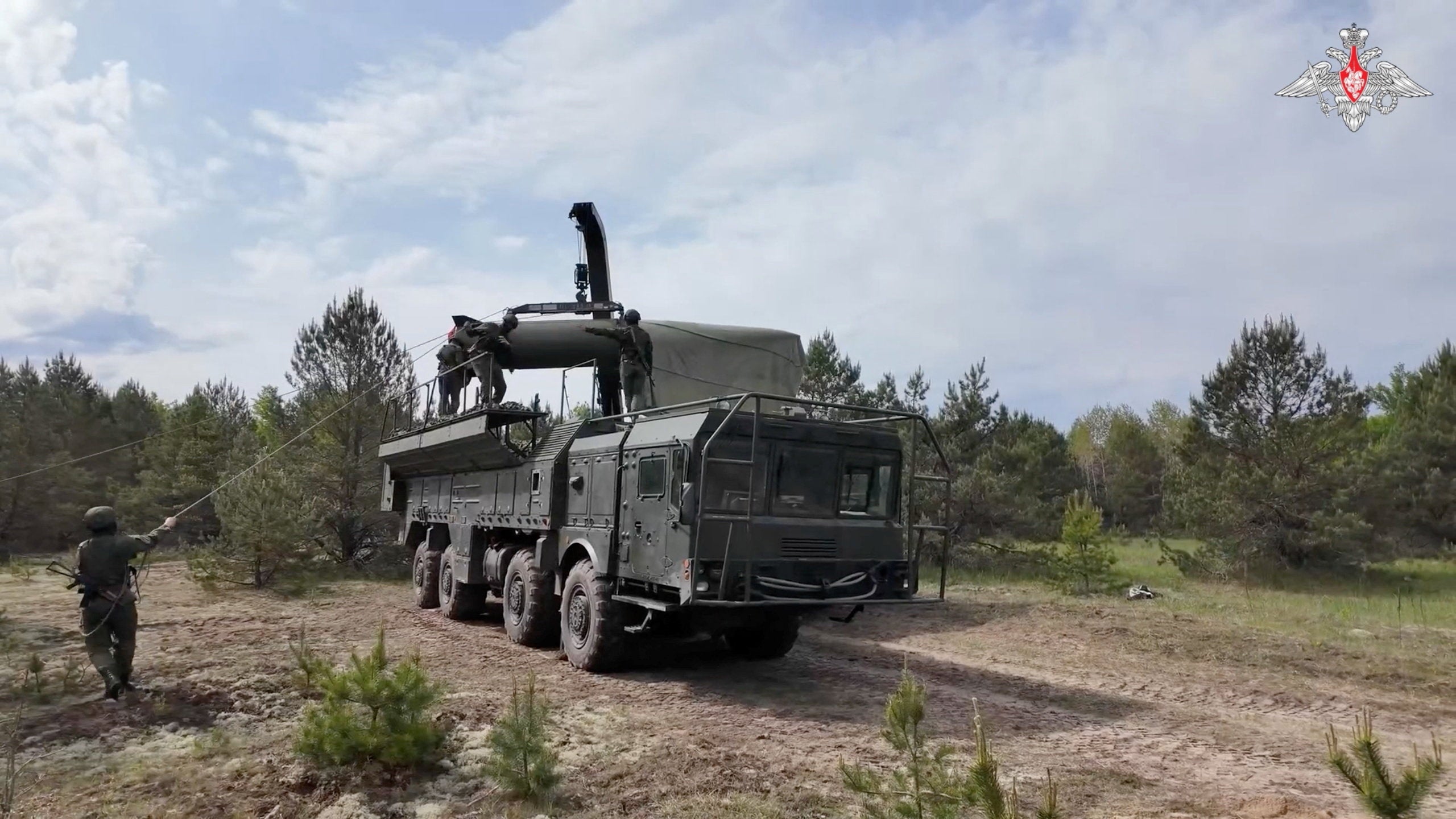 Service members mount a missile on a Russian Iskander-M missile launcher during nuclear forces exercises at an unidentified location in Belarus