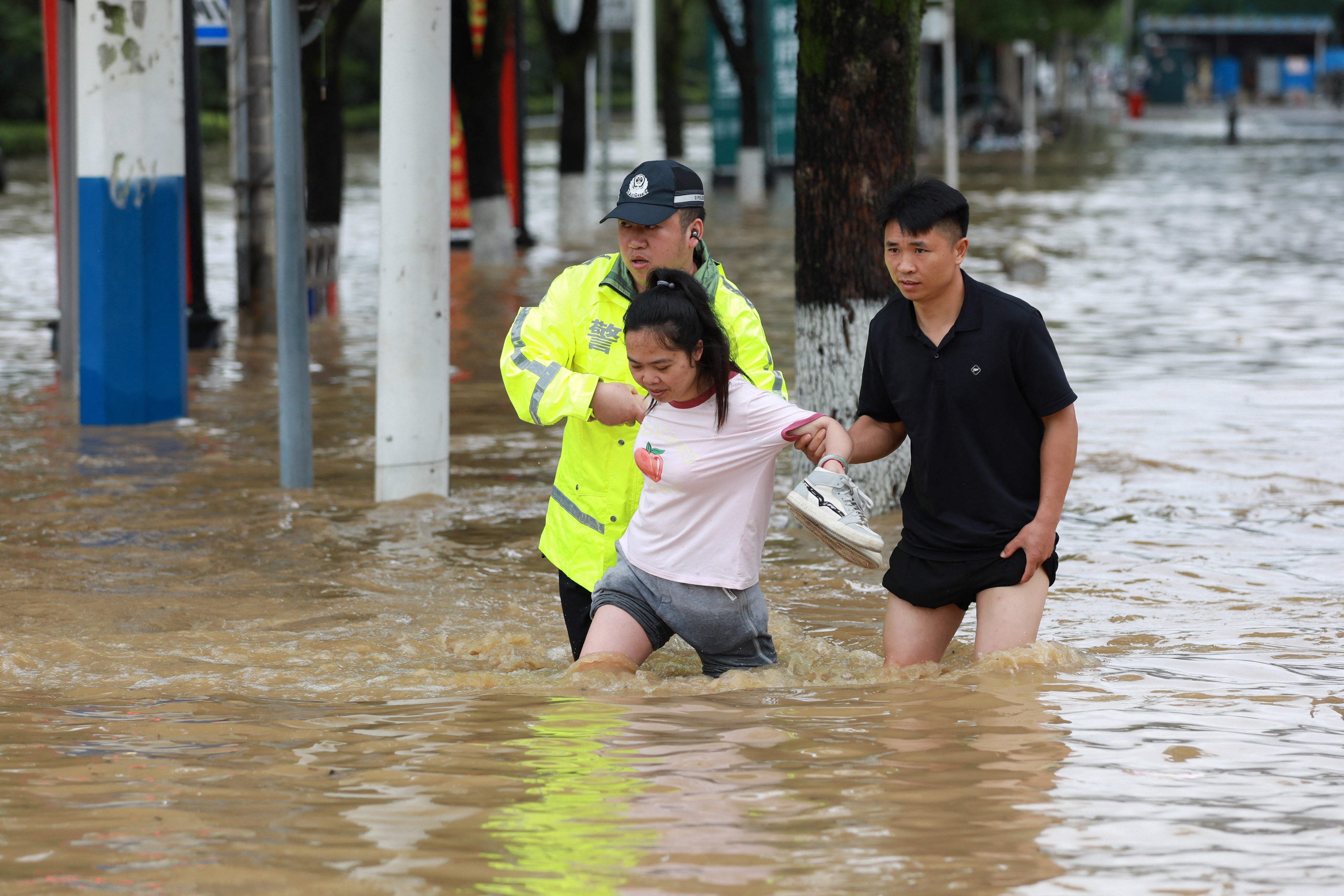 A police officer (L) helps a woman crossing a flooded road in Duyun, in China's southwestern Guizhou province (AFP/Getty)
