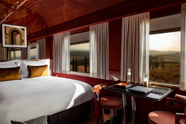 <p>A deluxe suite comes with a bed, a small table and a sofa</p>