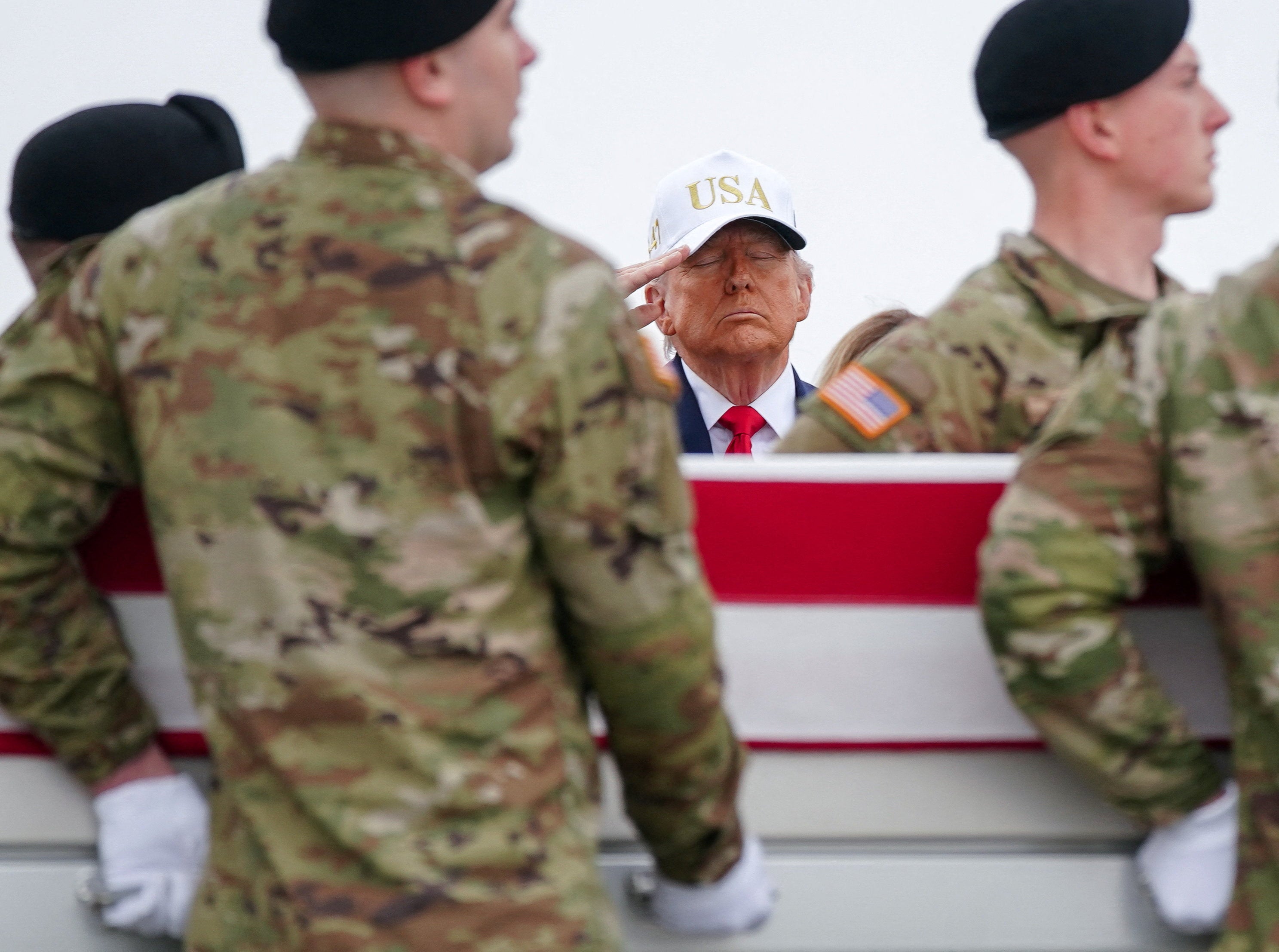 Donald Trump salutes as members of the military carry a transfer case during a dignified transfer of the remains of six U.S. Army service members killed in Kuwait, deaths that survivors say could have been prevented with adequate medical resources