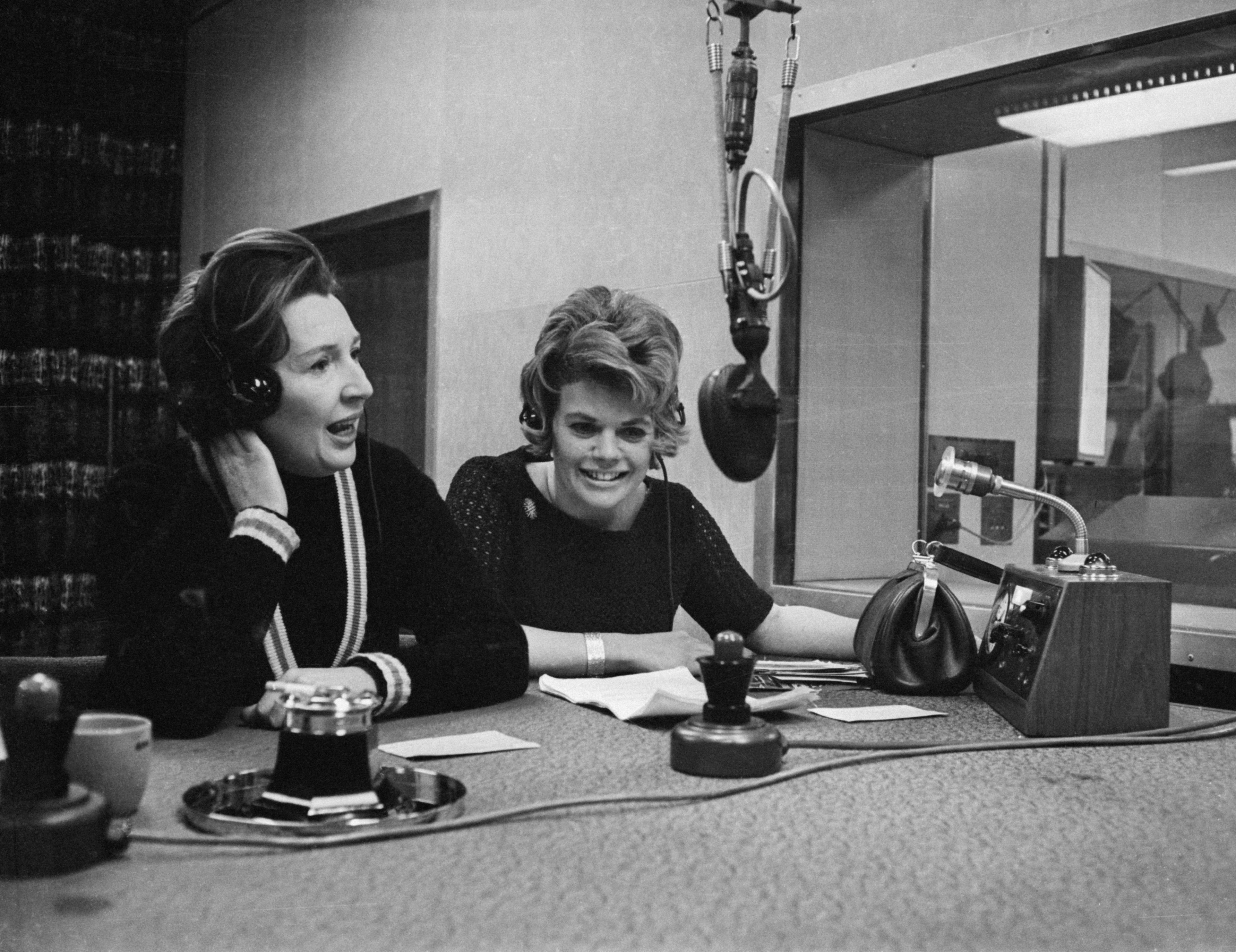 Jean Metcalfe (à esquerda) e Judith Chalmers apresentando um programa de rádio da BBC 'Two Way Family Favourite', em 1965
