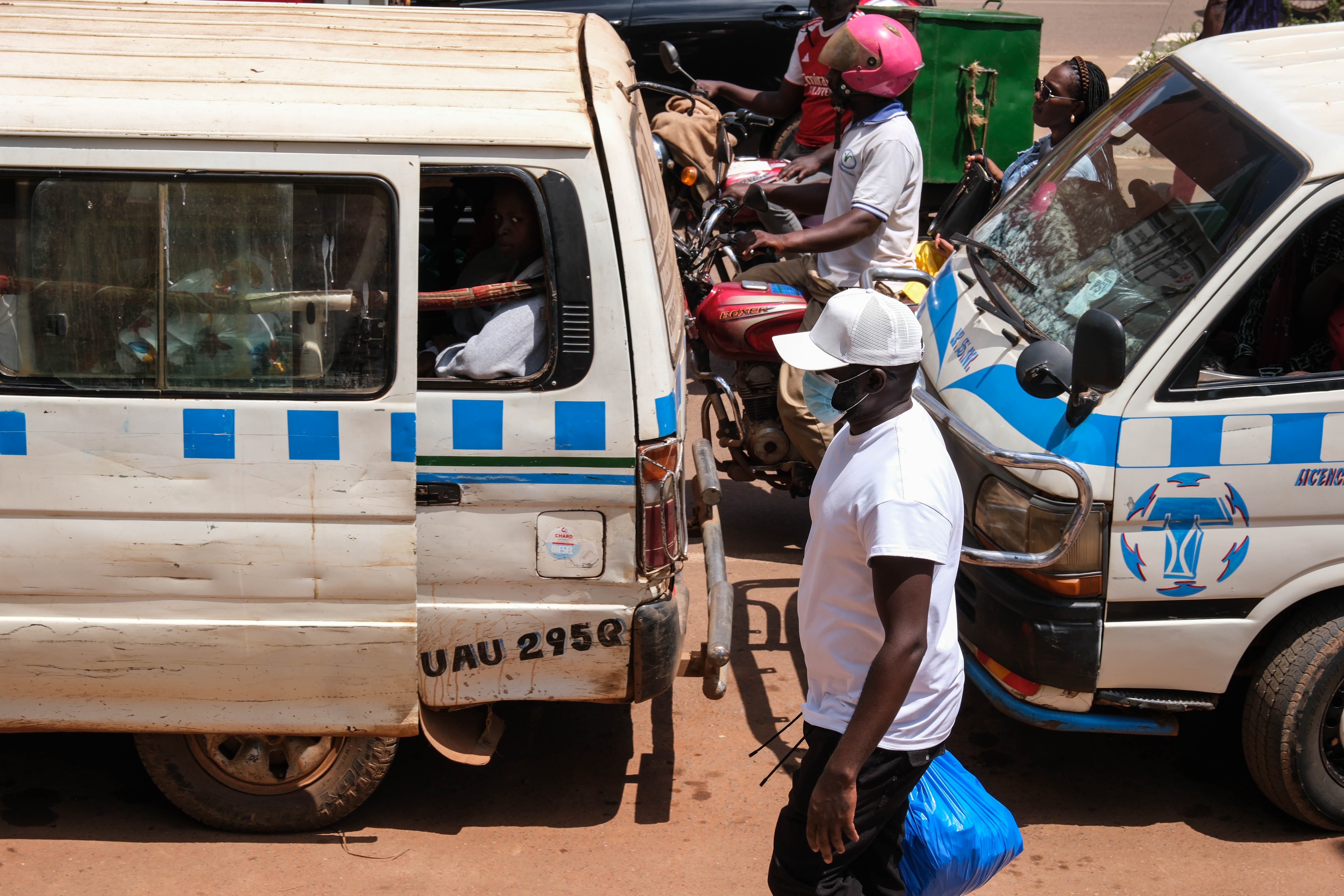 A man wearing a protective mask walks along a busy street in Kampala, Uganda, Tuesday, May 19, 2026