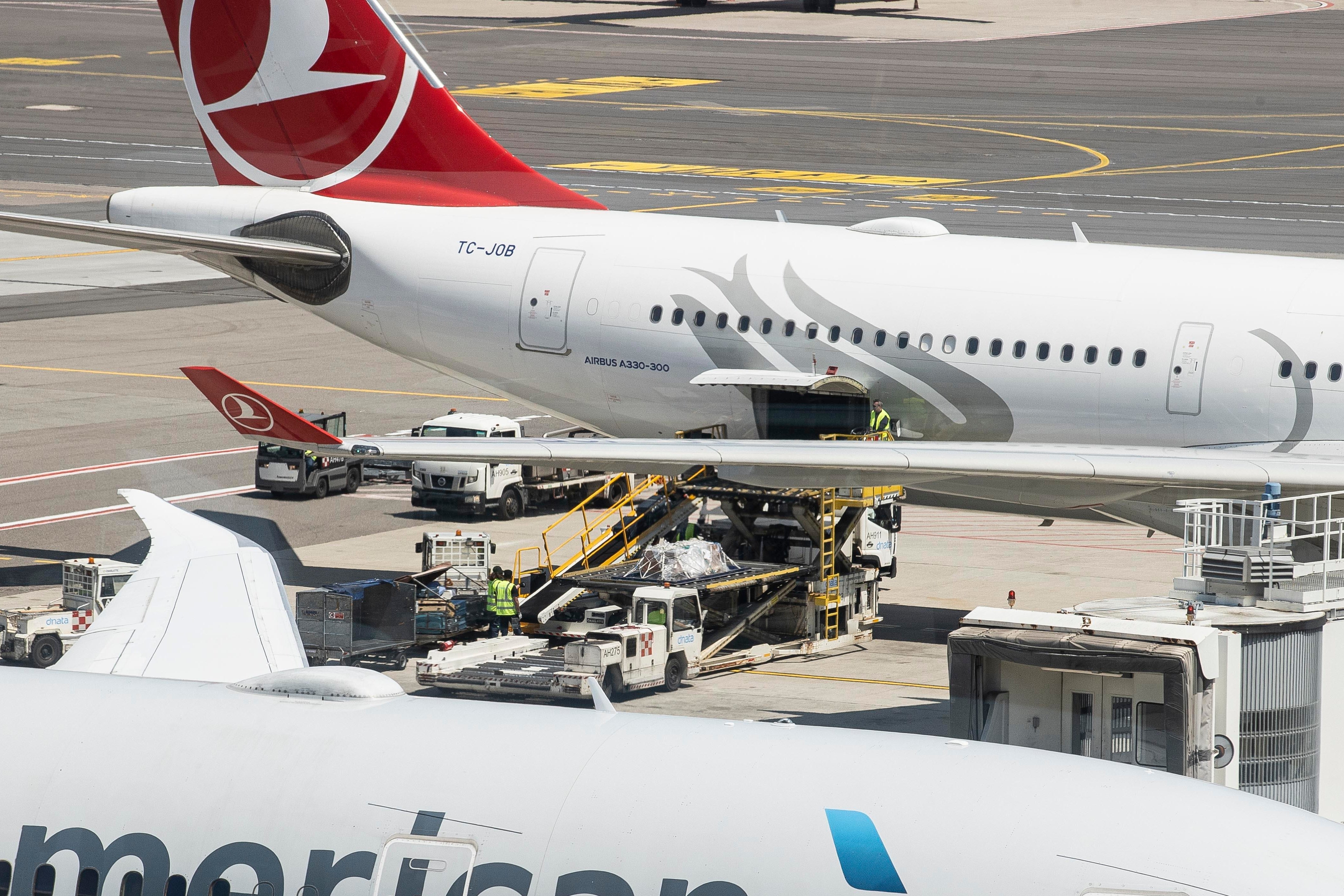 Coffins carrying the bodies of the divers who died in the Maldives are unloaded from a plane at Milan's Malpensa airport, Italy, Saturday, May 23, 2026