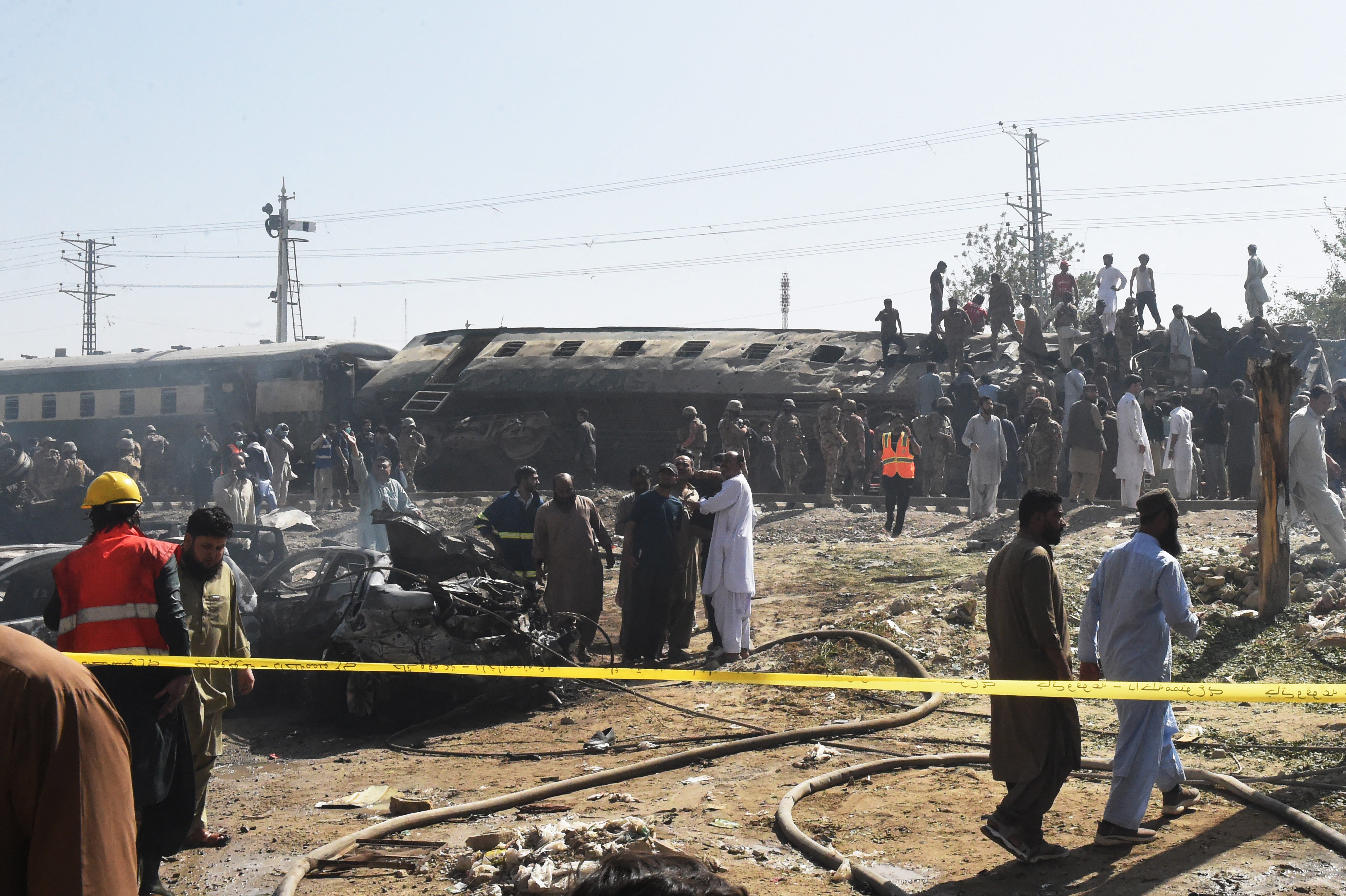 Security personnel inspect damaged derailed carriages after an explosion targeted a train in Quetta