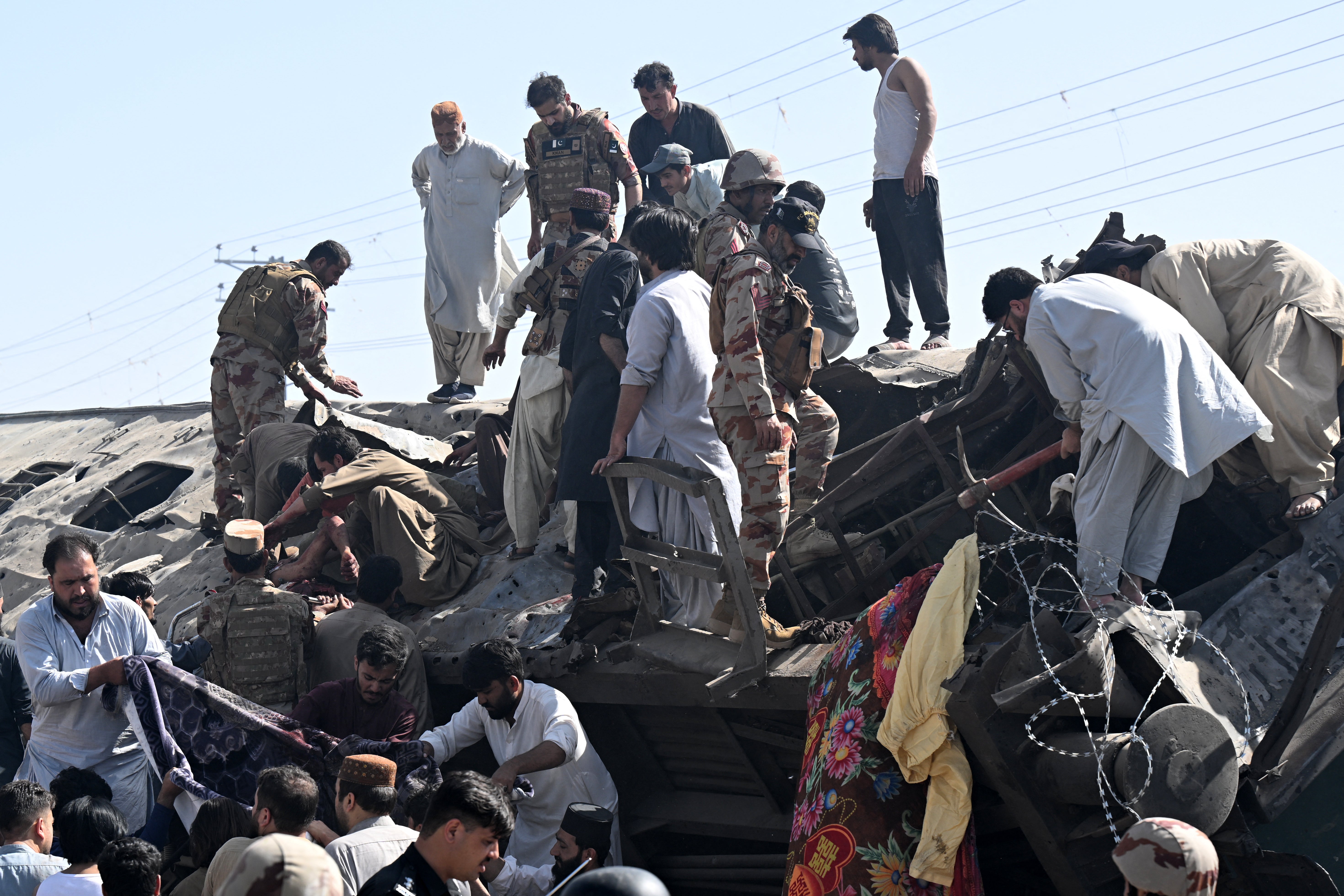 Security personnel and residents rescue injured blast victims from derailed carriages after an explosion targeted a train in Quetta