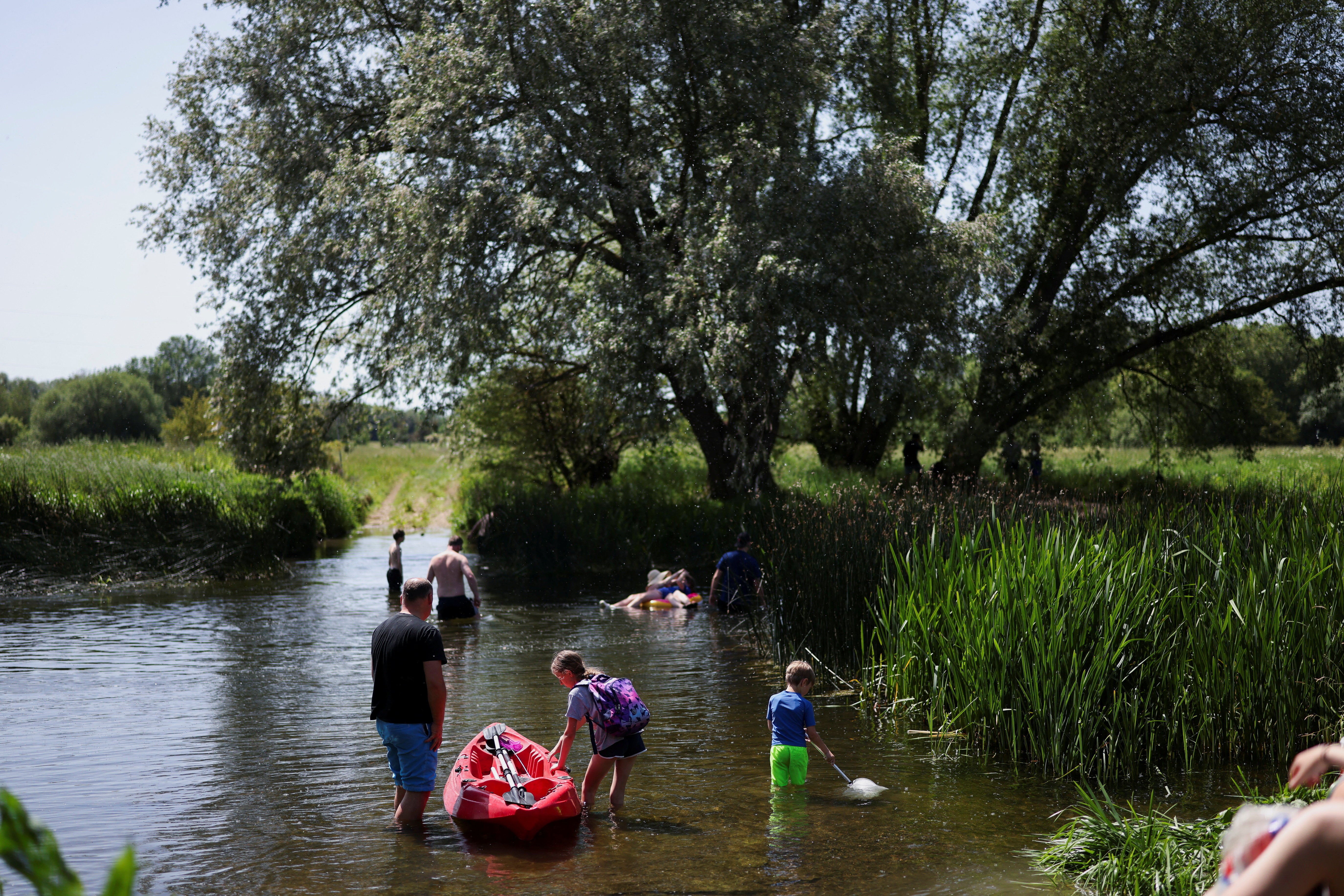 People cool off in the water of the River Great Ouse as temperatures climb over the bank holiday weekend during a heatwave (Reuters)