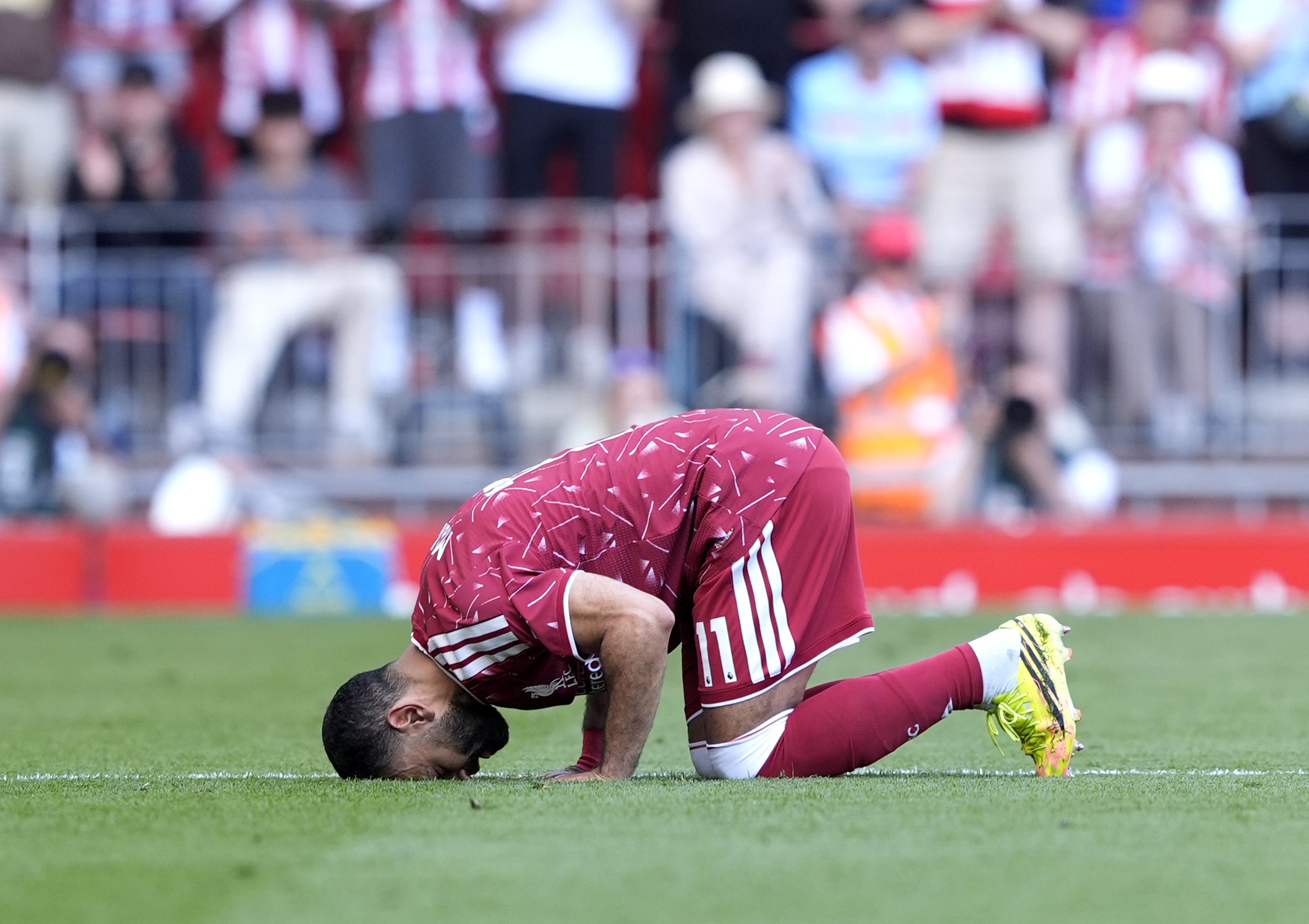 Salah kisses the pitch as he is substituted off on his final appearance (Peter Byrne/PA)