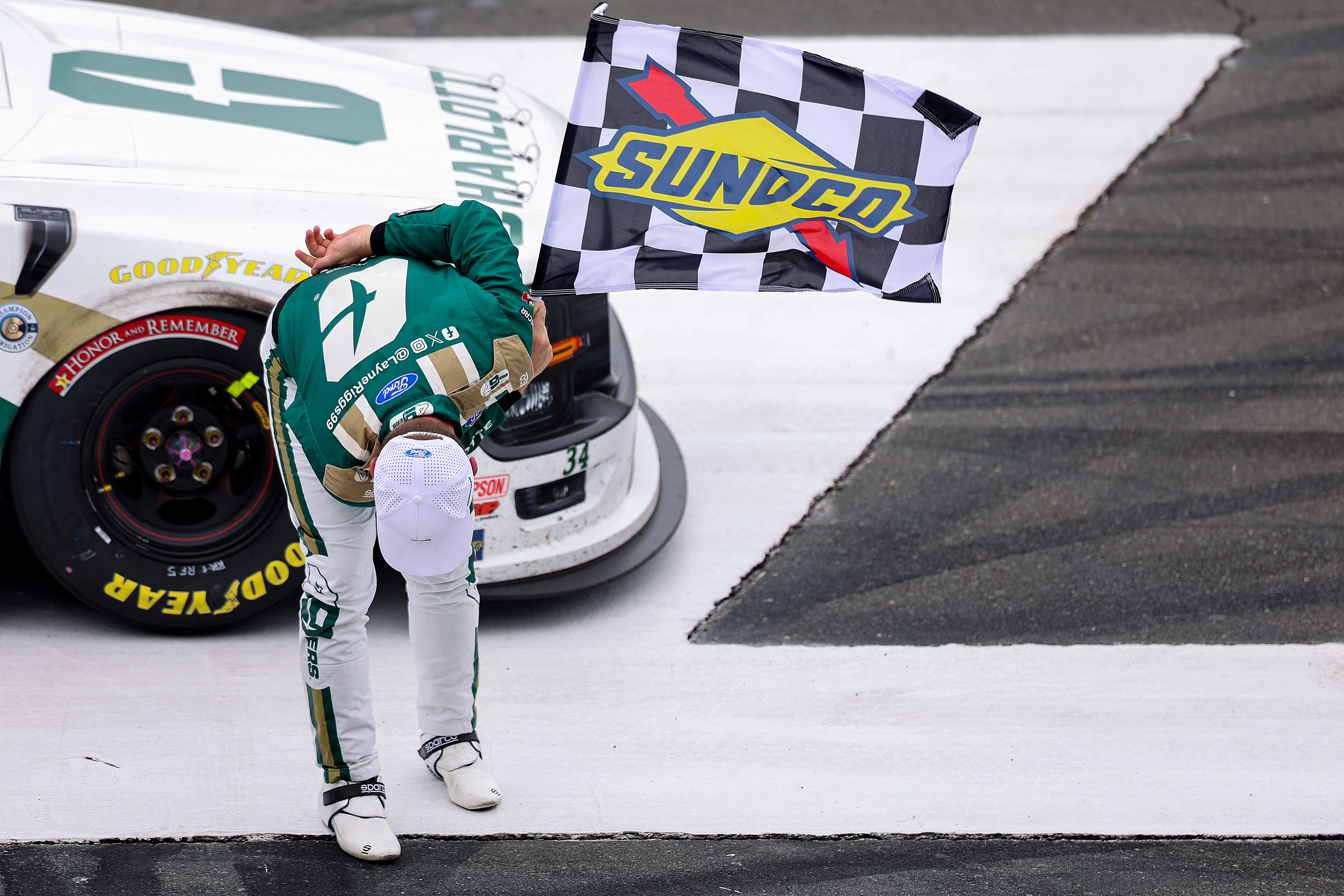 Layne Riggs, driver of the #34 University of North Carolina at Charlotte Ford, takes a bow in tribute to the late Kyle Busch after winning the NASCAR Craftsman Truck Series North Carolina Education Lottery 200