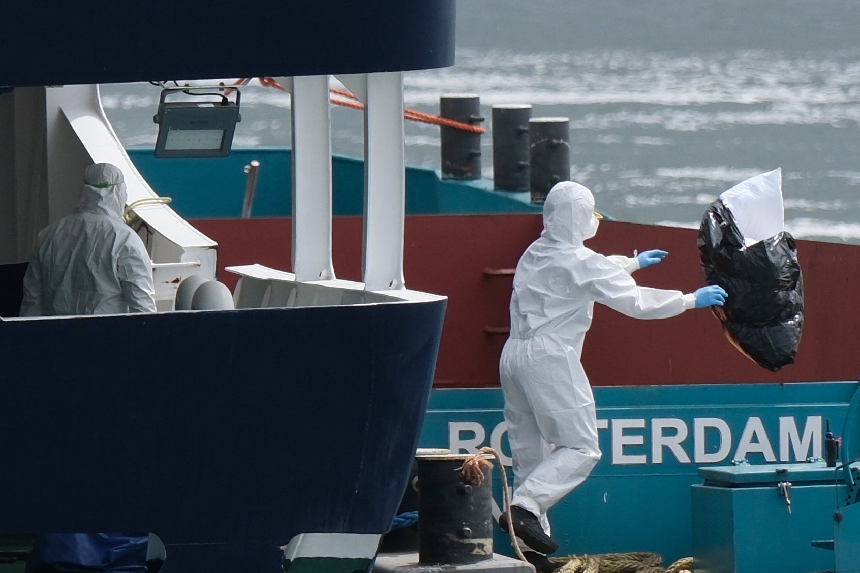 People in protective gear remove waste from the MV Hondius cruise ship after its arrival at the Port of Rotterdam, Netherlands, Monday, May 18, 2026 (AP Photo/Patrick Post)