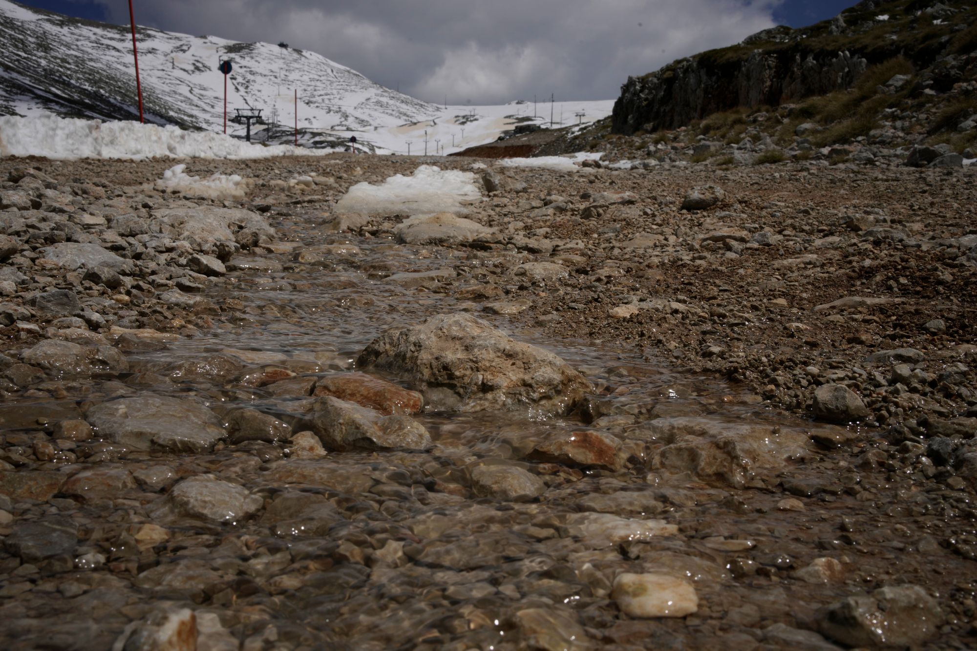 Water from melting snow flows down the slopes of Mount Parnassos at the Kelaria ski center in central Greece, on May 5, 2026