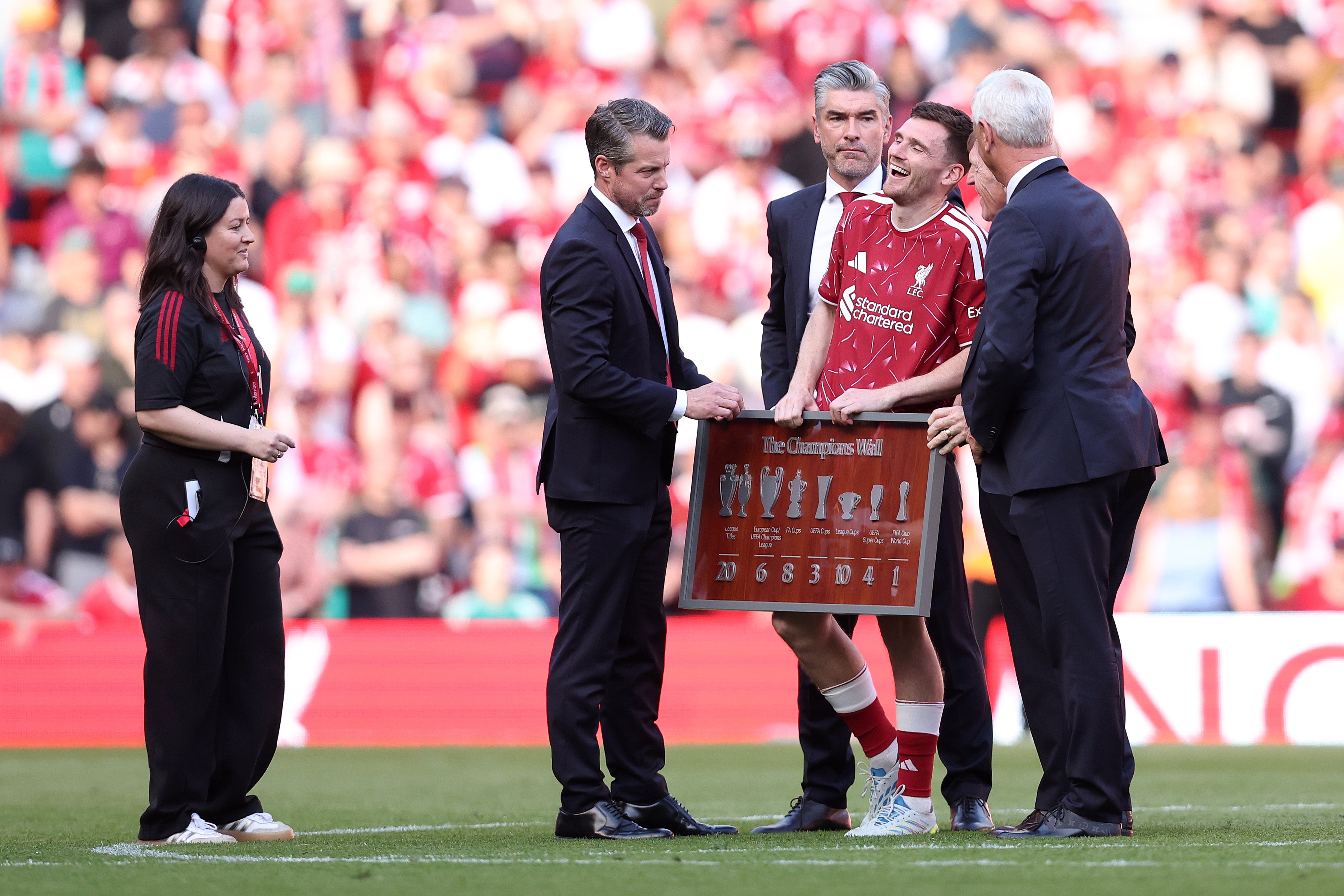 Andy Robertson of Liverpool reacts as he is presented with a frame by CEO Billy Hogan, Sporting Director Richard Hughes, and former Liverpool players Kenny Dalglish and Ian Rush (Getty)