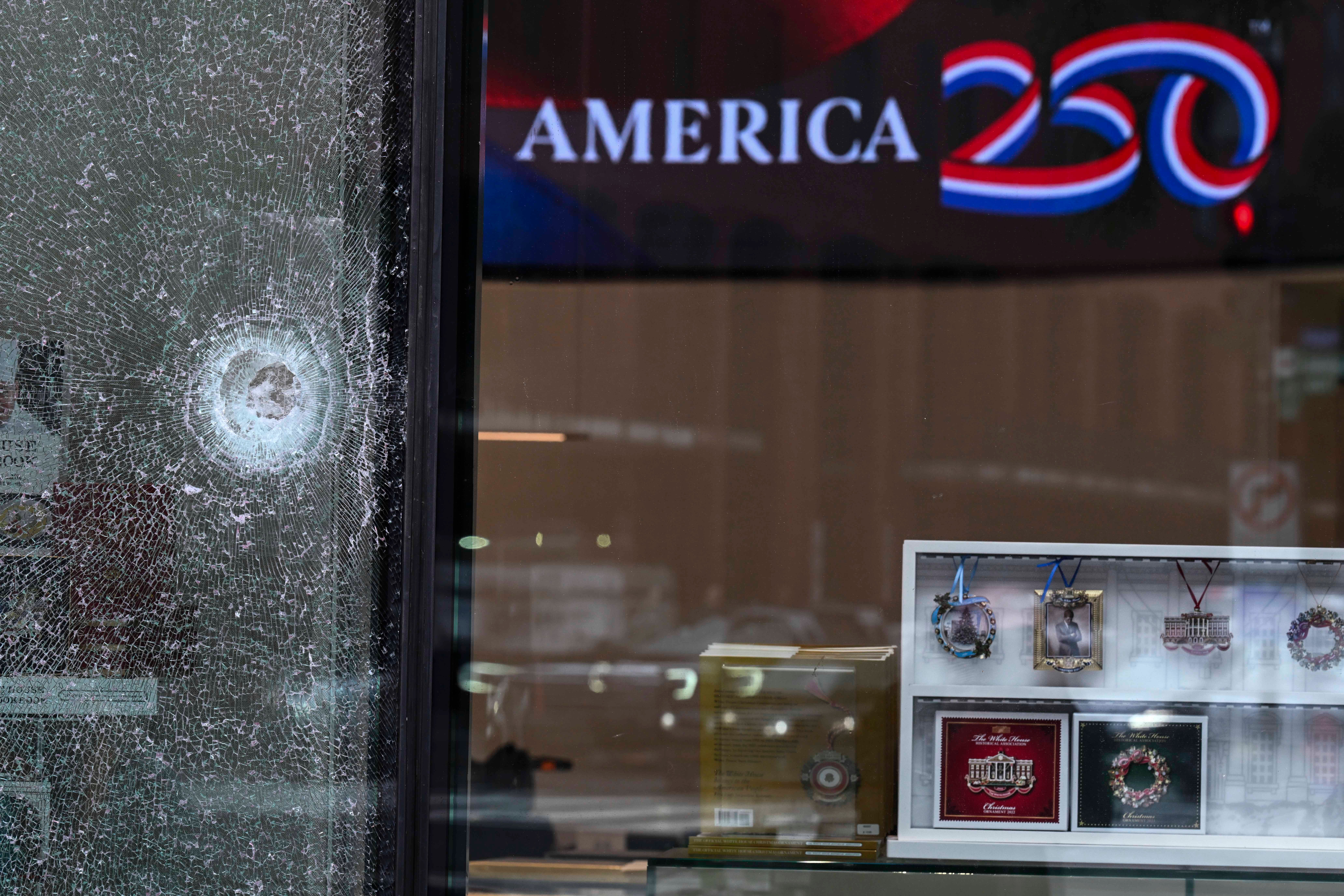 A bullet hole is seen in a window of The People's House: A White House Experience after the shooting near the White House