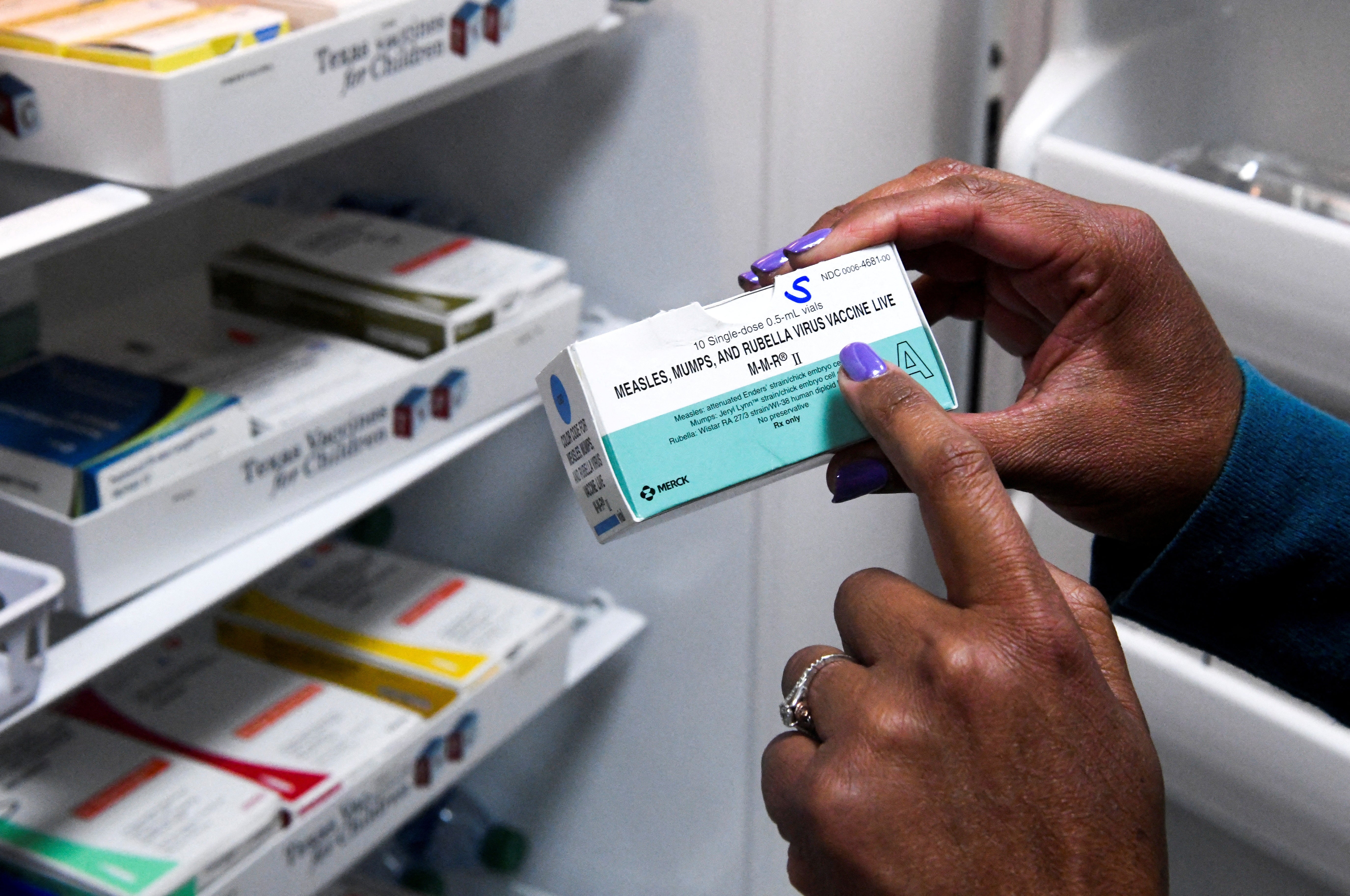 A doctor holds a measles-mumps-rubella vaccine box during last March’s outbreak in West Texas. Increased vaccination rates were credited for ending an outbreak in South Carolina earlier this year