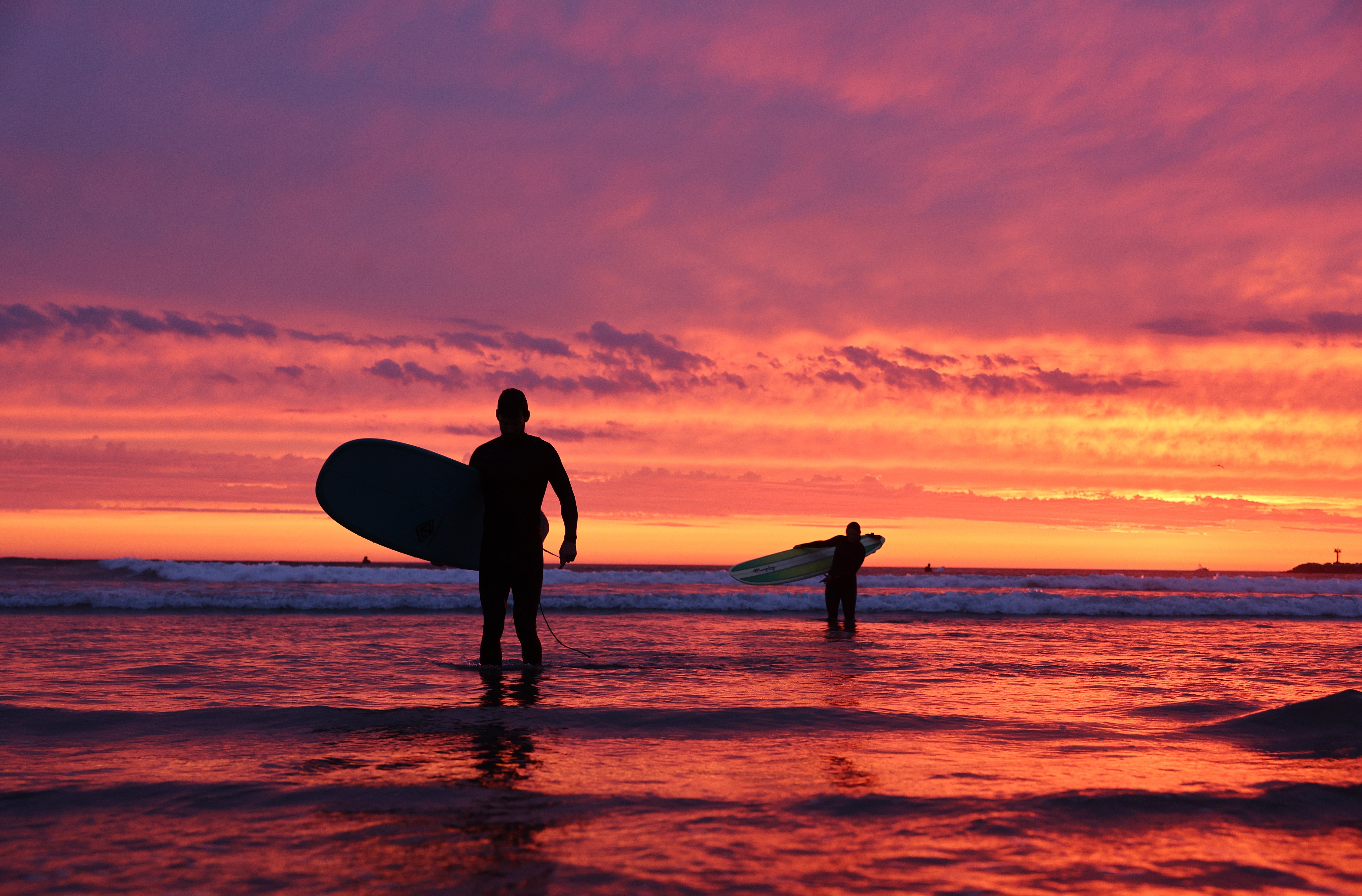 Surfers walk out of the waters at Ocean Beach in San Diego, California, in August 2023. This summer season expected to be the longest of the next decade