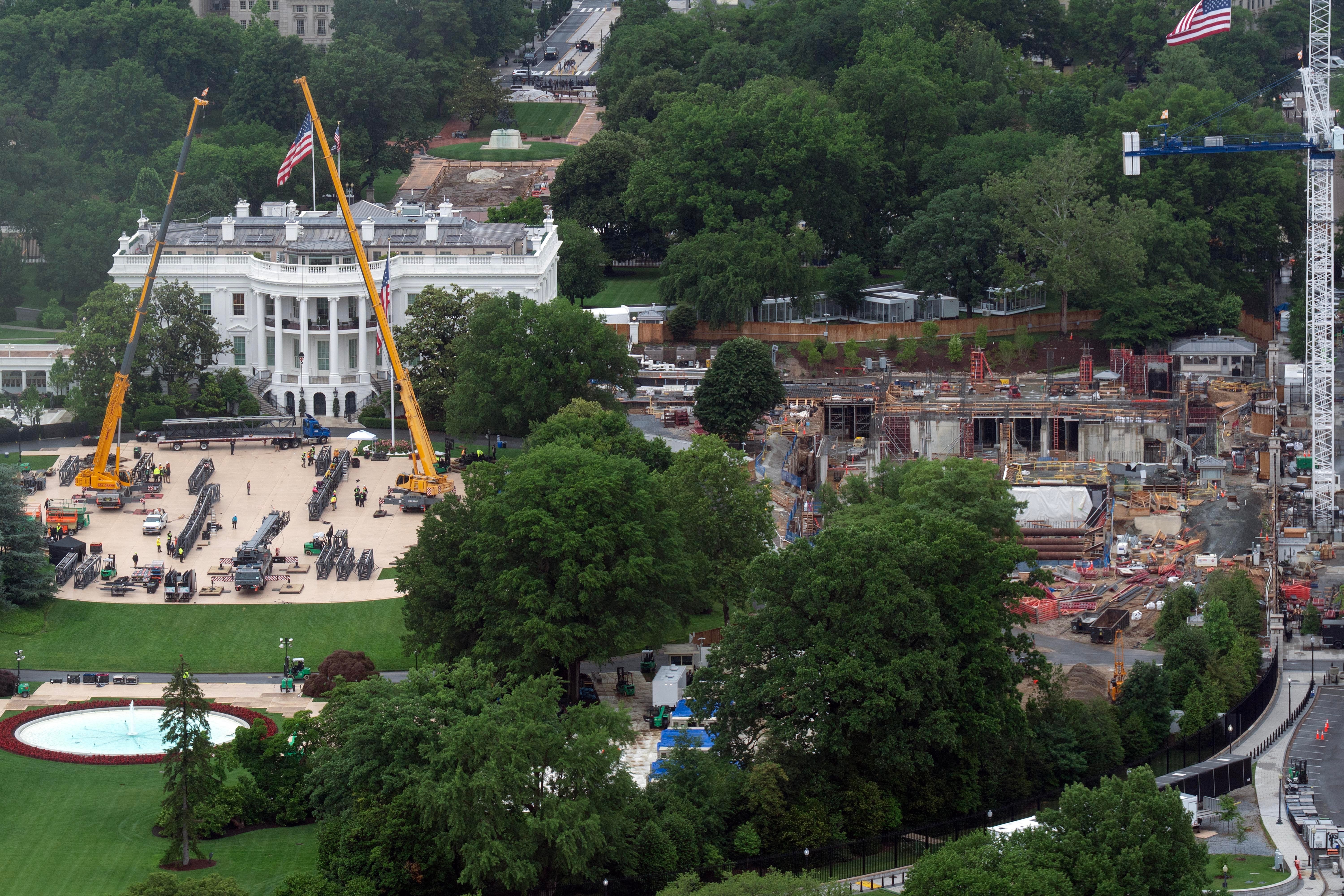 Two massive yellow cranes were seen towering over the South Lawn as pieces of the rig lay on the ground below, one photo taken Saturday appears to show