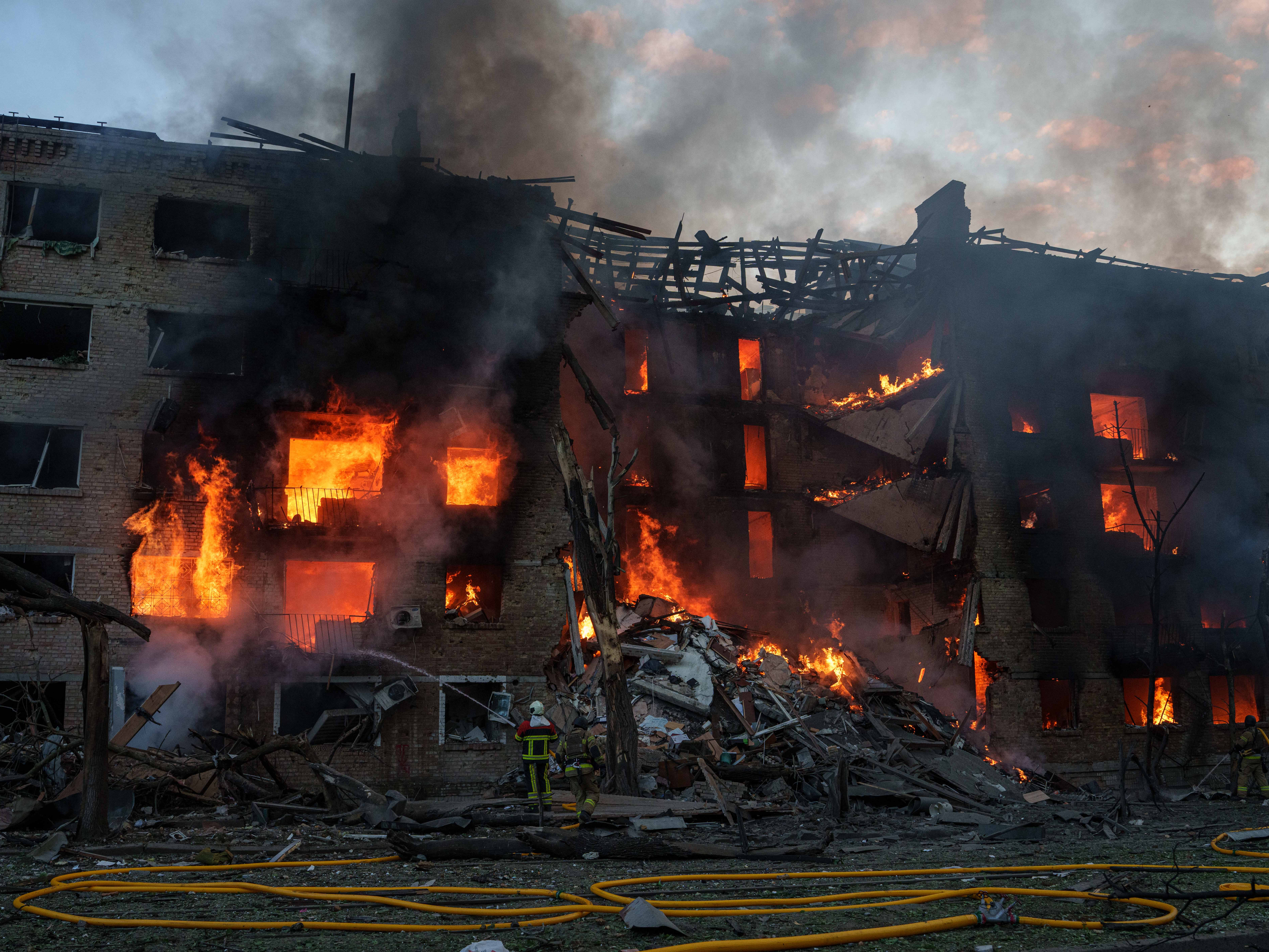 Rescue workers try to put out a fire at a residential building after a Russian strike on Kyiv.