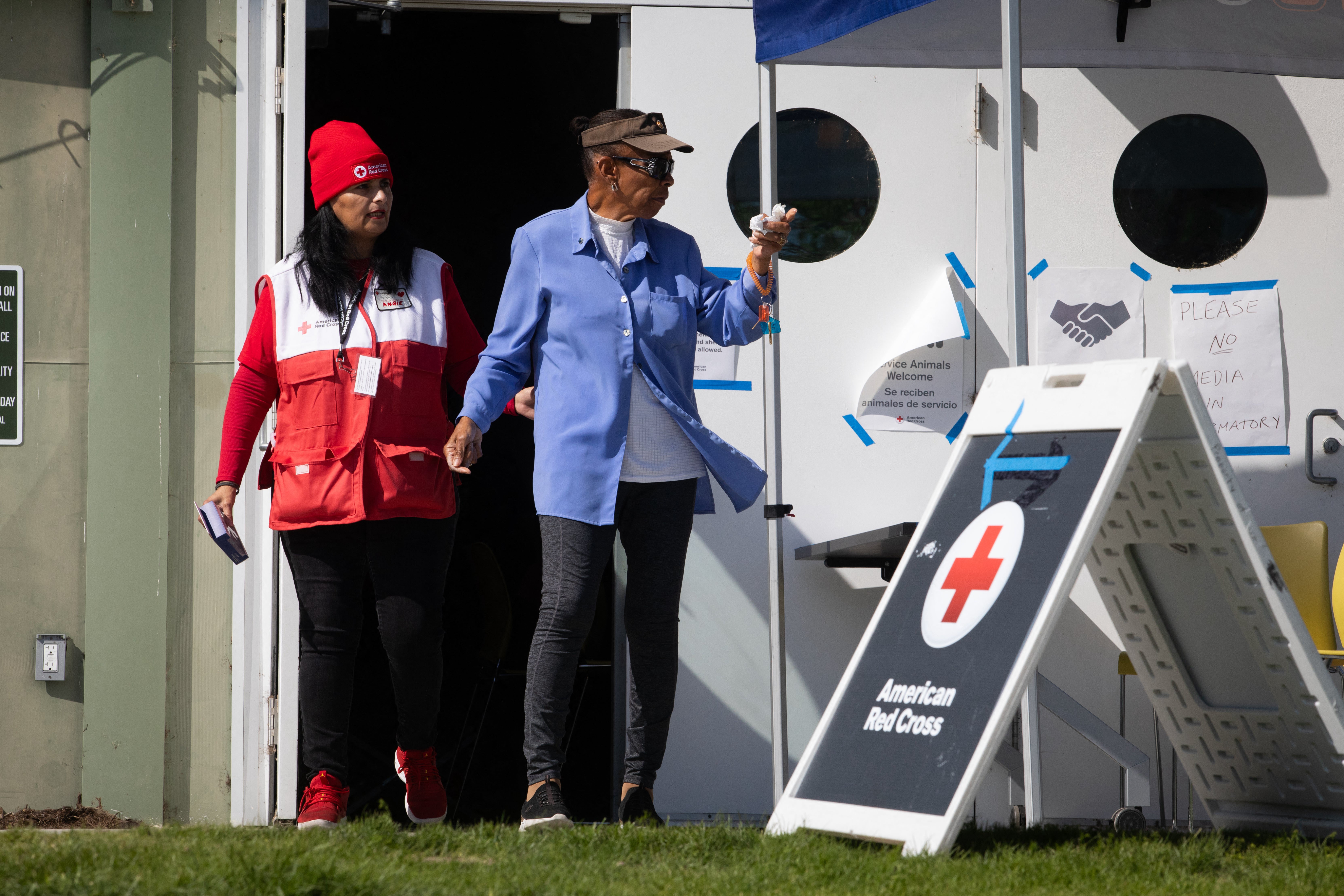 An American Red Cross member walks with an evacuee at a shelter in Fountain Valley, California,