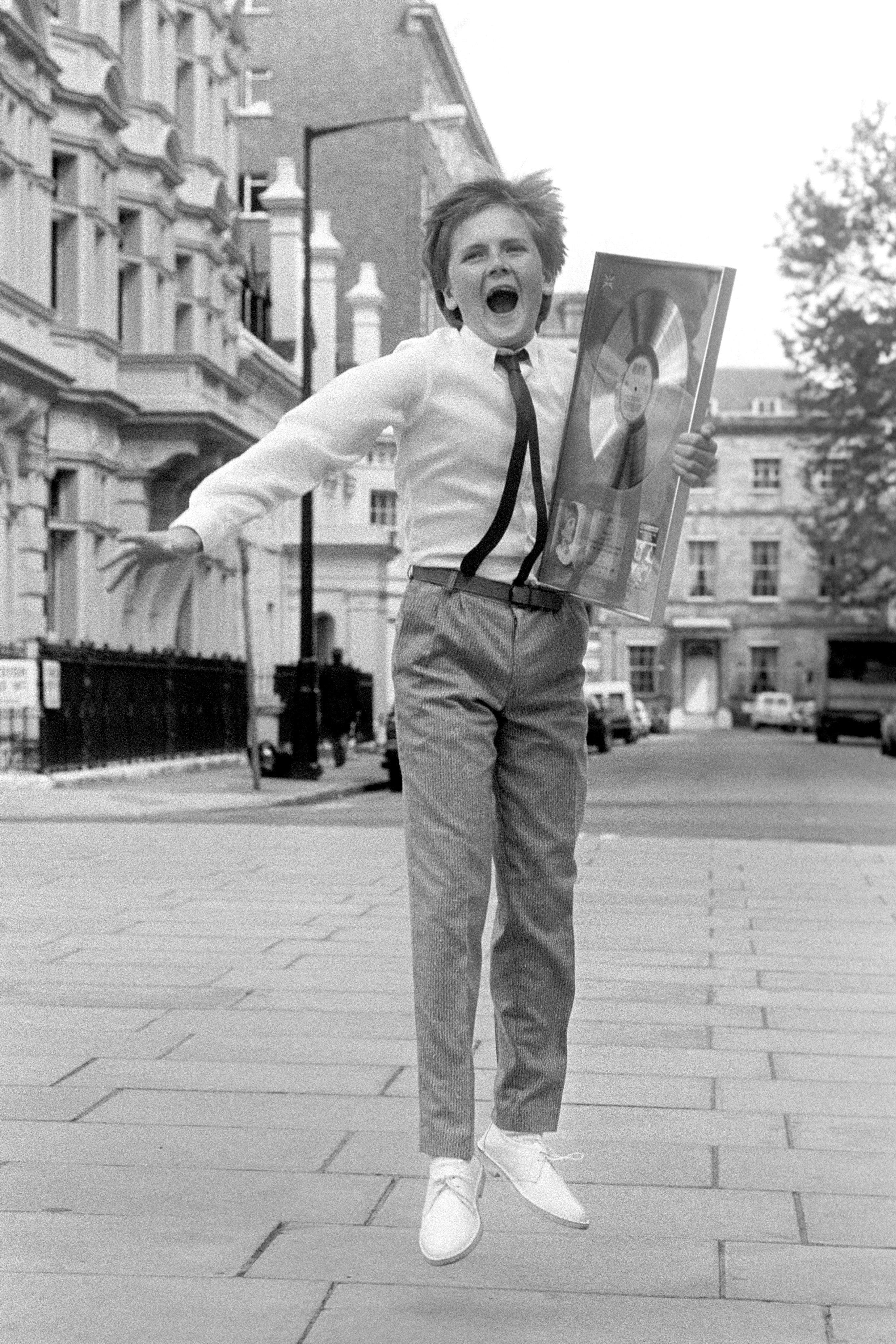 Aled Jones, aged 14, jumping for joy after collecting a silver disc for the best-selling album 'Voices from the Holy Land'