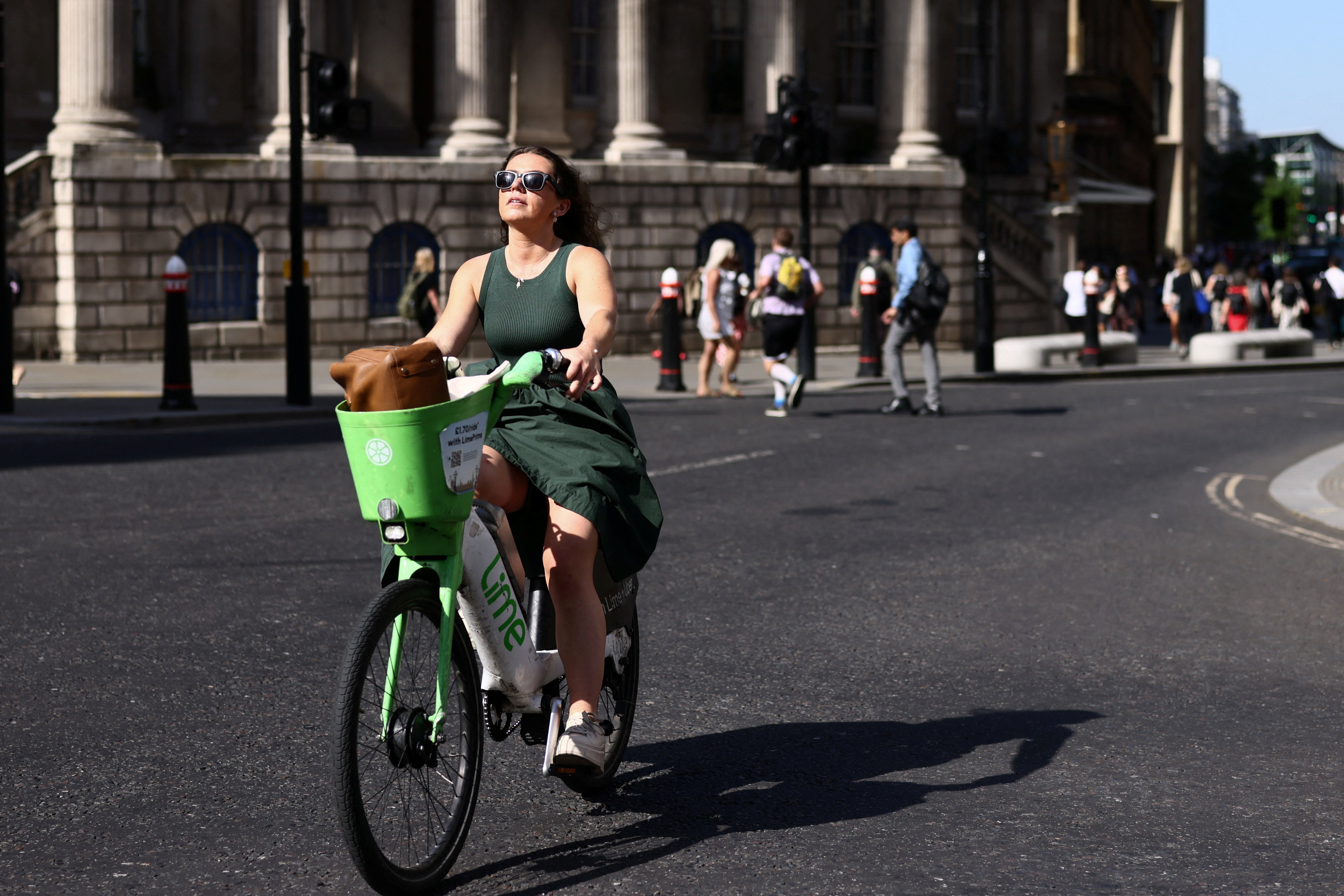 A woman rides a Lime bike during a heatwave in London, Britain, May 26