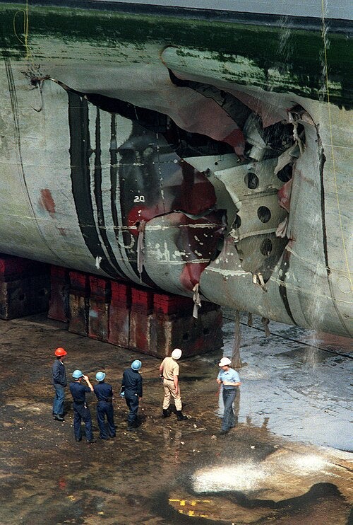 Repair crews inspect the hold that was ripped open in the hull of the amphibious assault ship USS Tripoli when the ship struck an Iraqi mine in February 1991