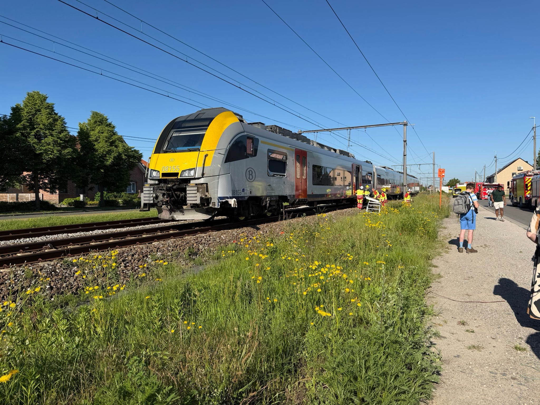Rescue workers on the scene of a crash between a train and vehicle in Buggenhout
