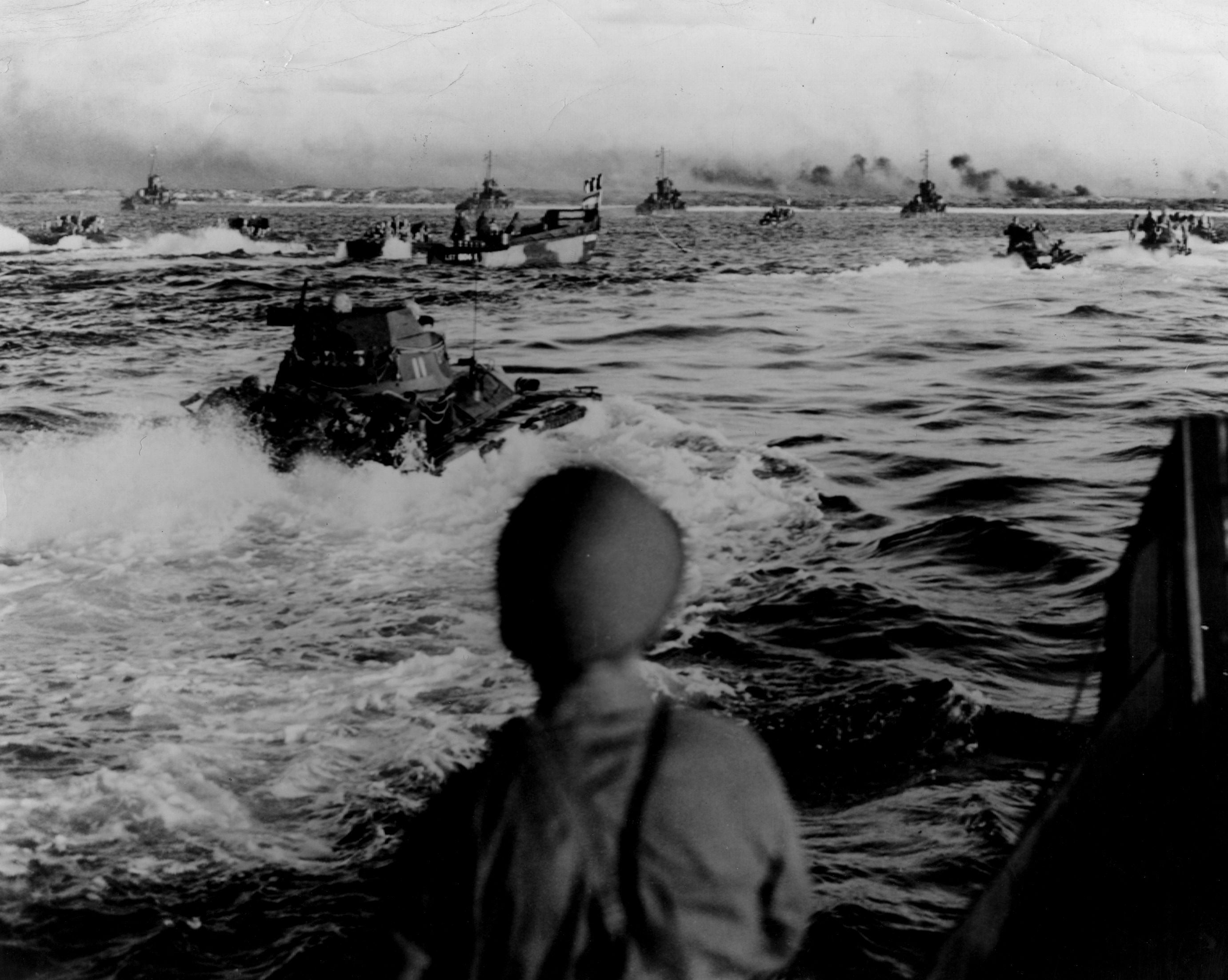 1945: American amphibious tanks and landing craft approach the beach at Aguni Jima, 30 miles west of Okinawa