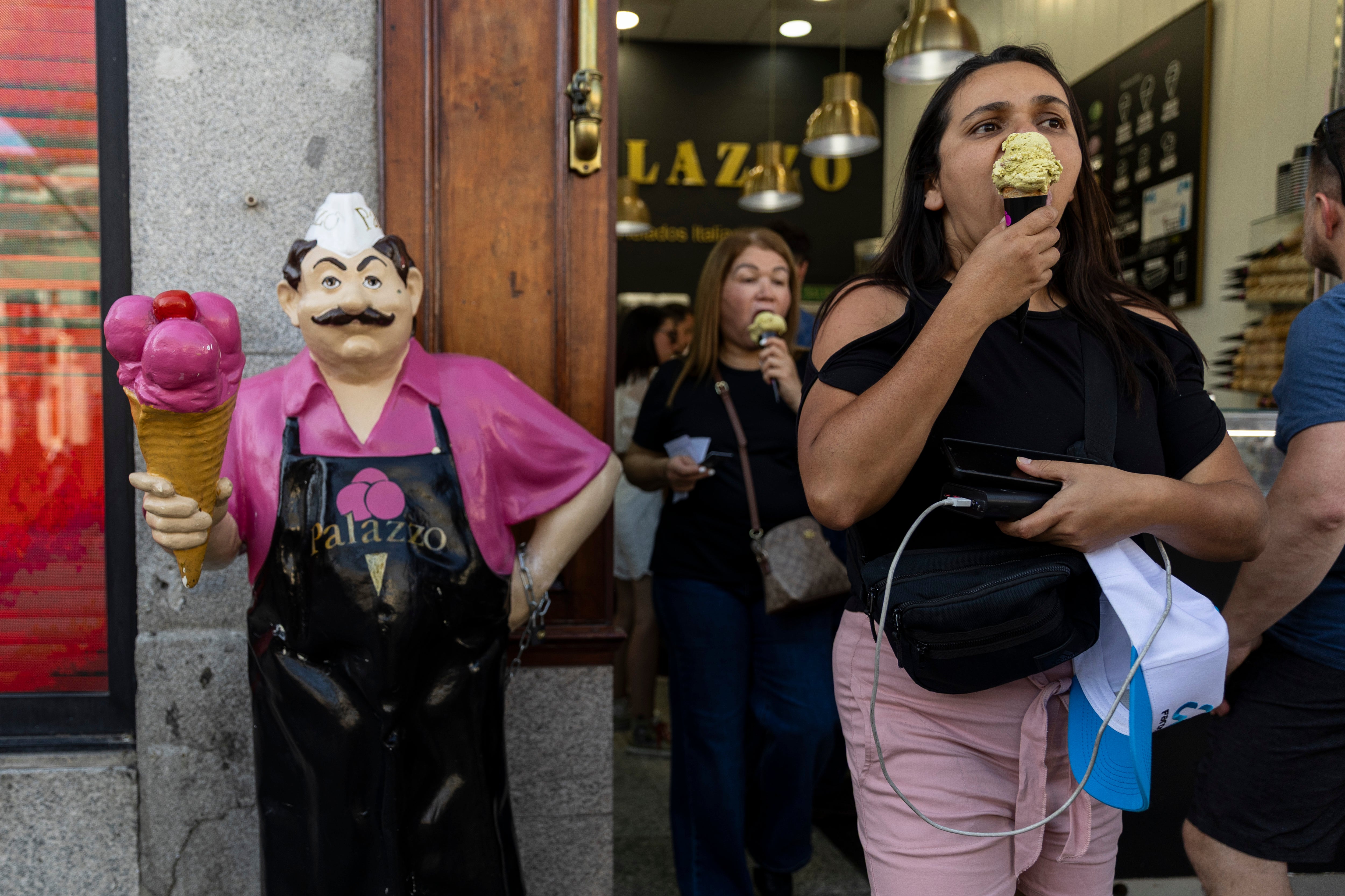 People buy ice-creams at Puerta del Sol square during an early heatwave in Madrid, on 23 May