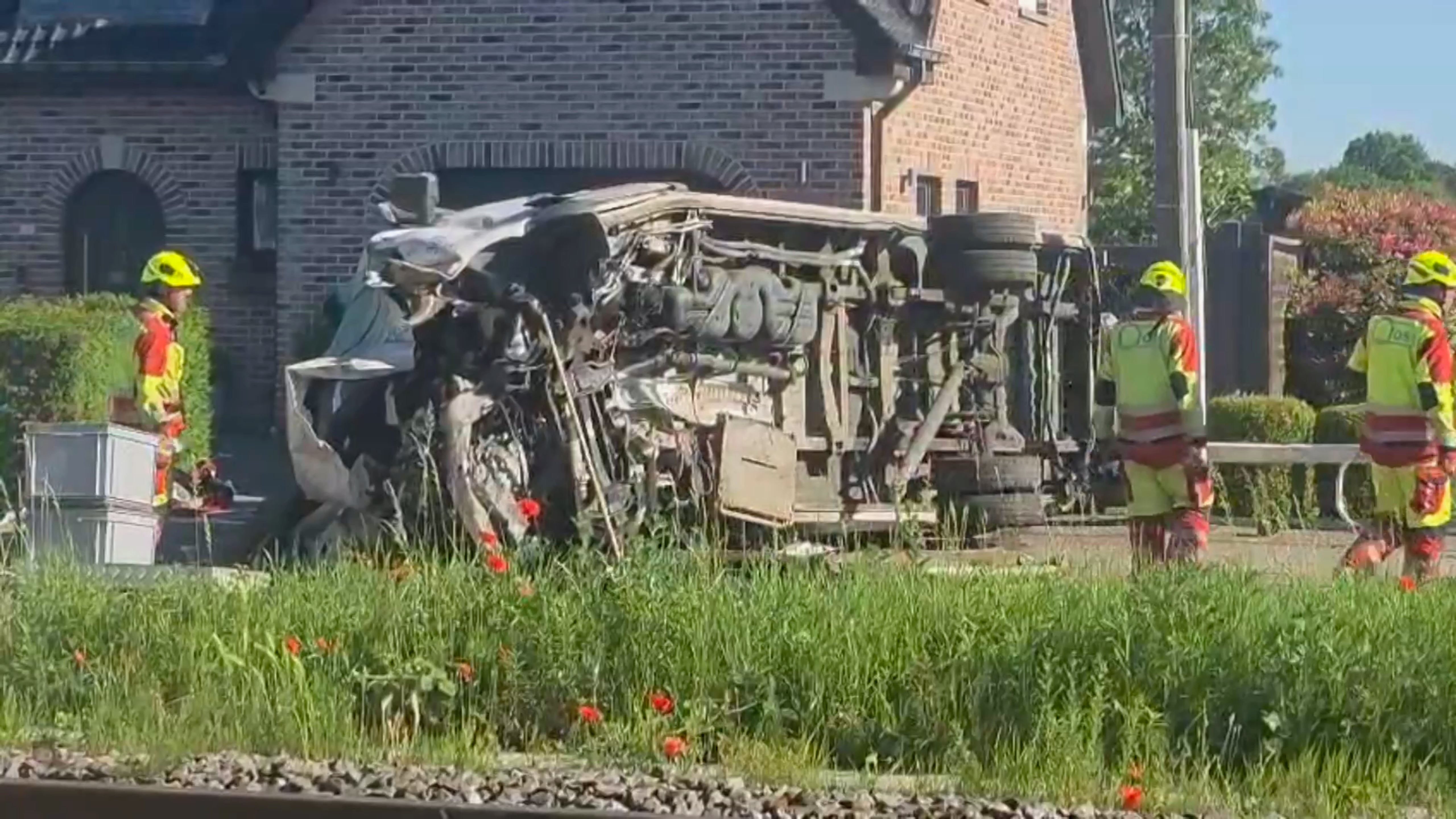 This video grab shows rescue workers on the scene of a crash between a train and vehicle in Buggenhout