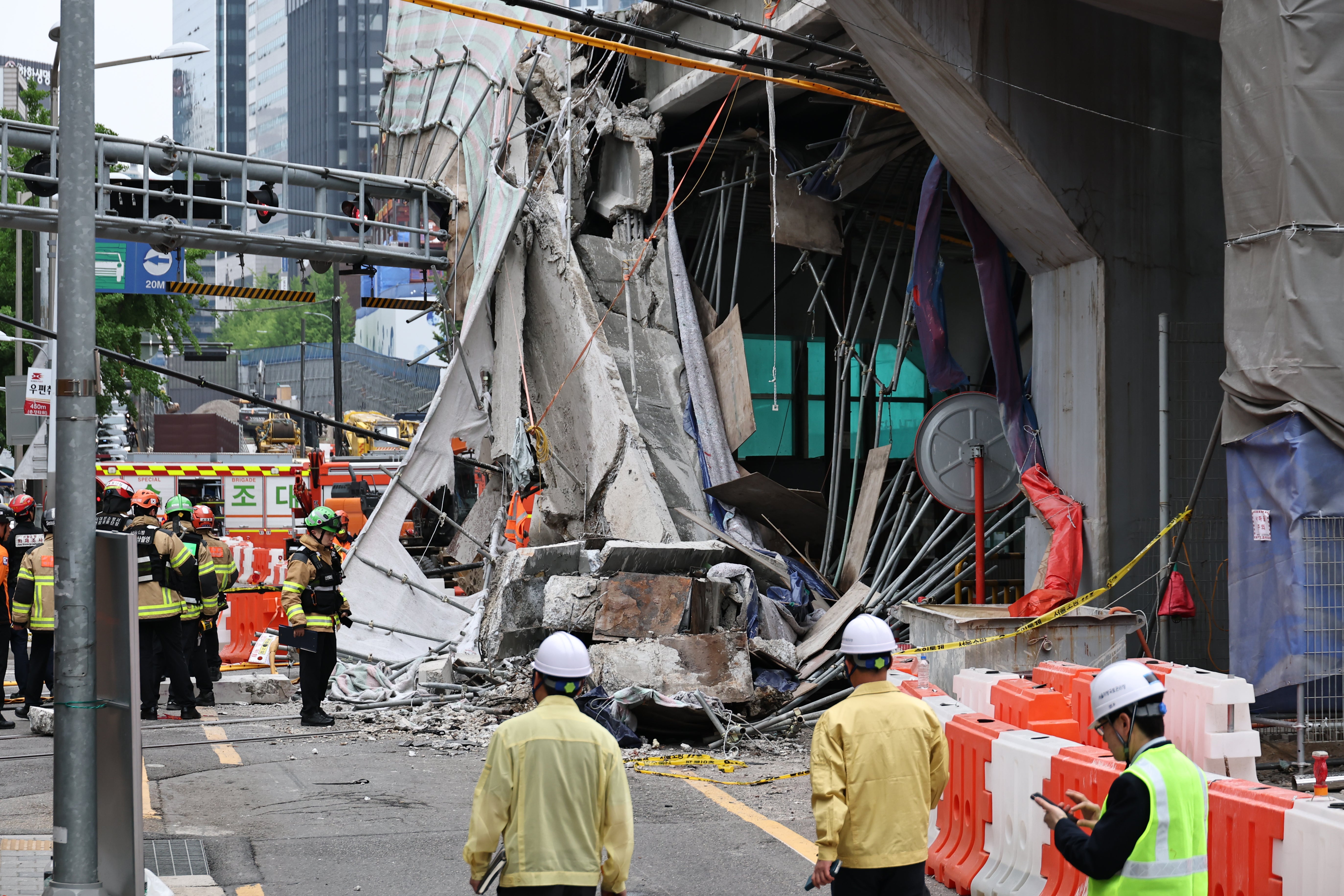 South Korean rescue team inspect the scene where an overpass collapsed while it was being dismantled in Seoul, South Korea, Tuesday