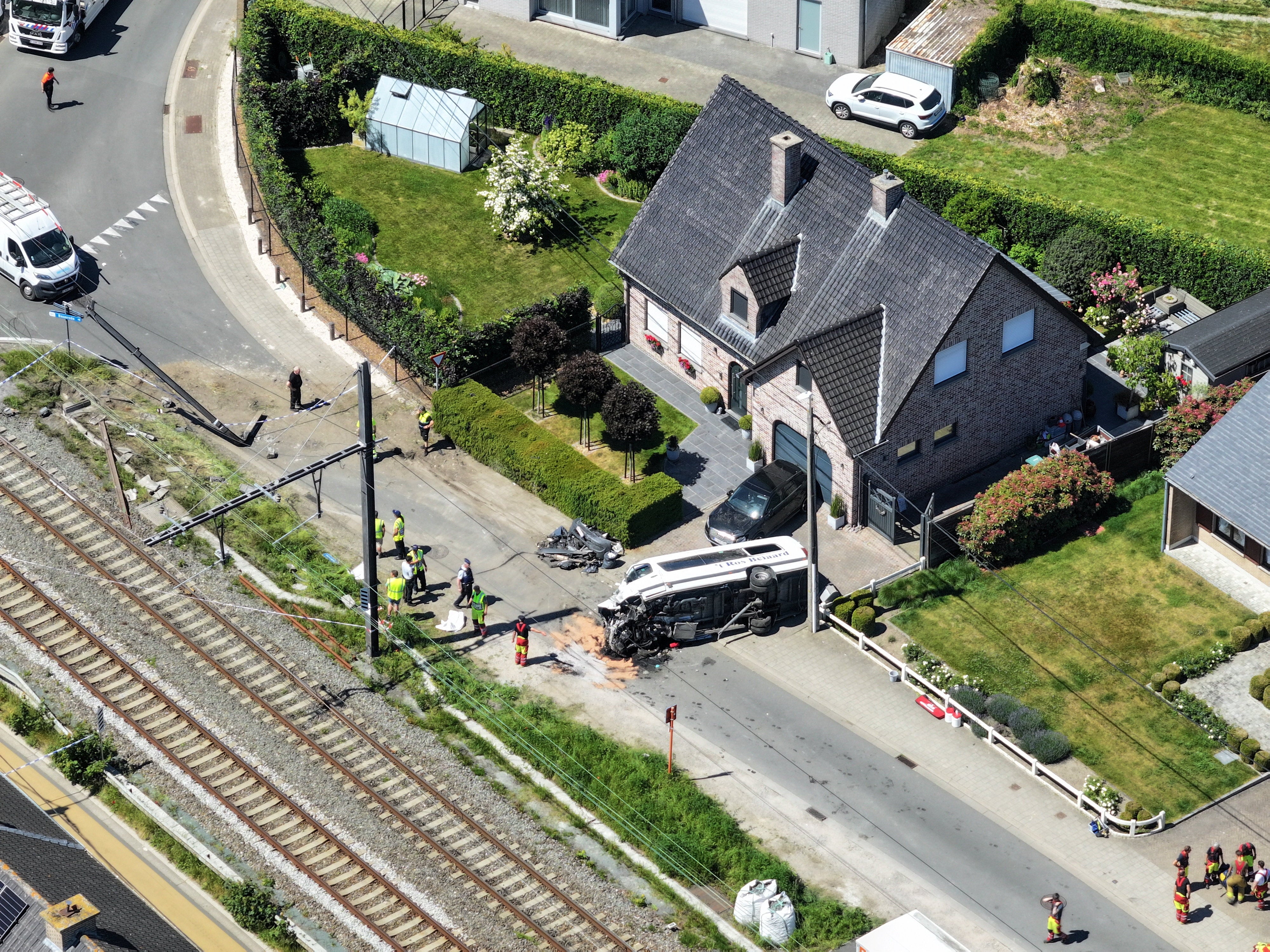 A drone view shows emergency personnel working near the damaged school bus that was struck by a train at a level crossing leading to multiple casualities, near the town of Buggenhout (Reuters)