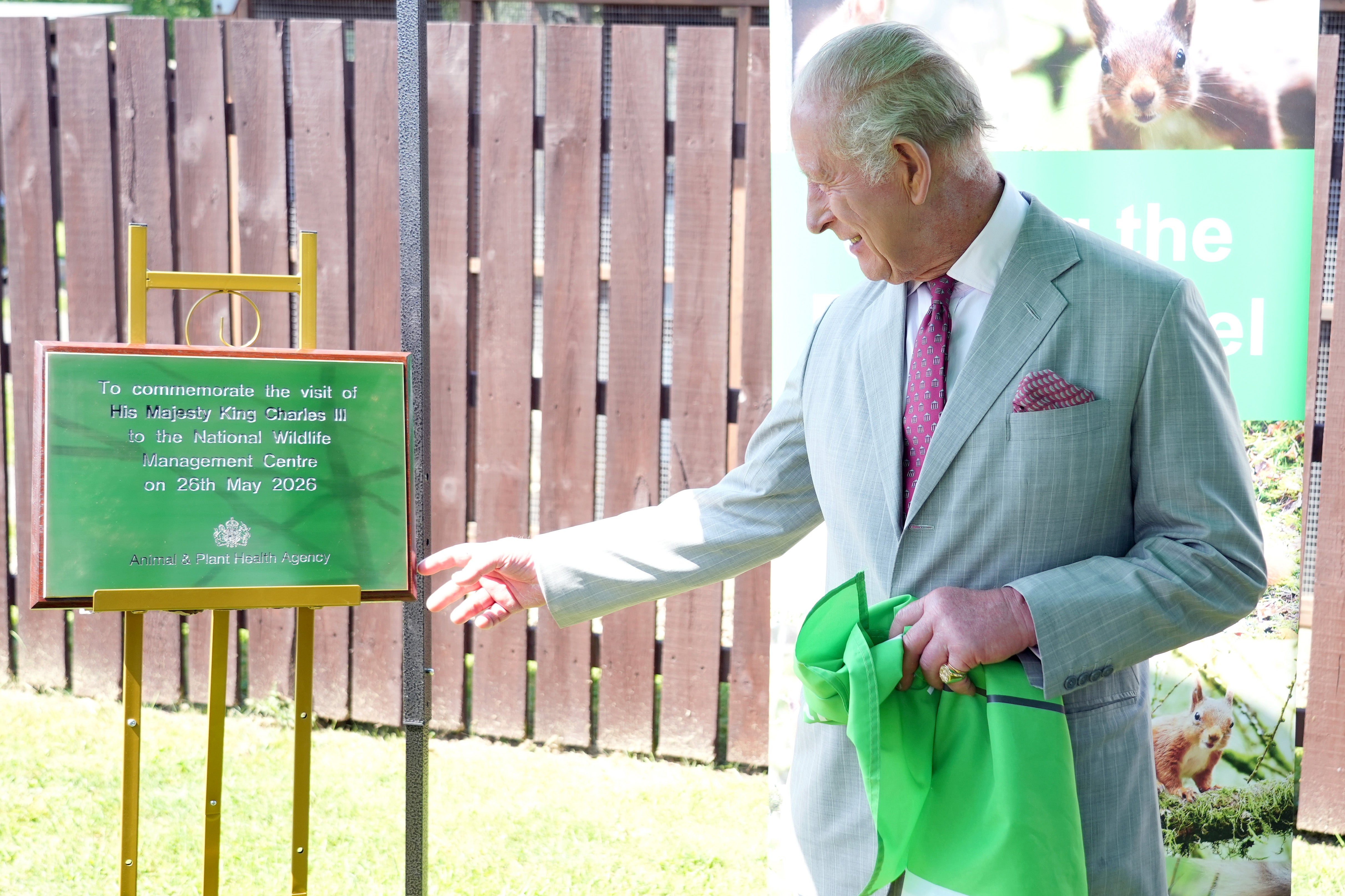 King Charles III unveils a plaque during a visit to a conservation initiative to humanely control grey squirrel numbers and support the endangered red squirrel population in the UK