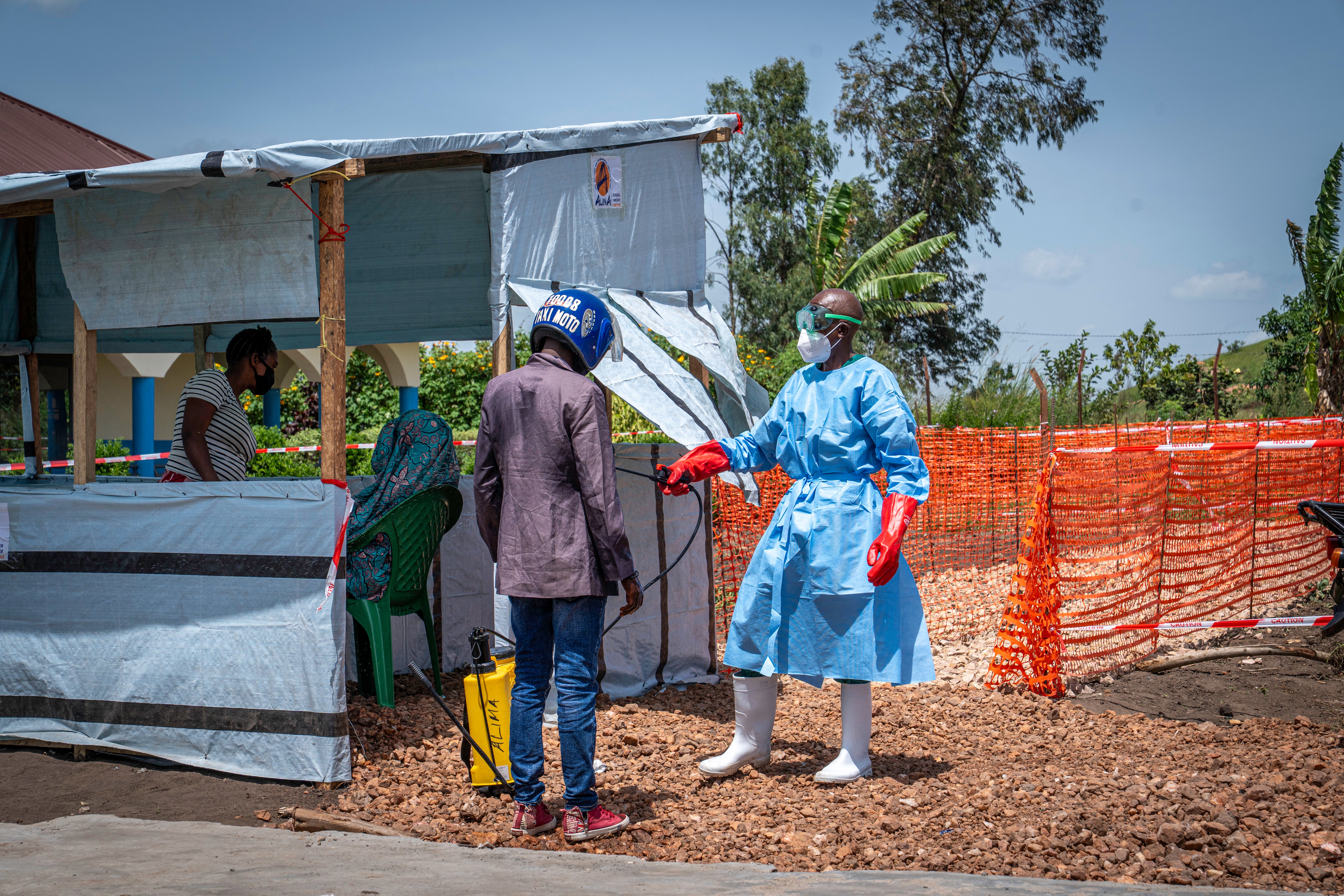 A health worker decontaminates the clothing of a motorcycle taxi driver who transported a patient suspected of having Ebola to the Rwampara Hospital in Ituri, in the eastern Democratic Republic of the Congo, on 26 May 2026 (AFP/Getty)