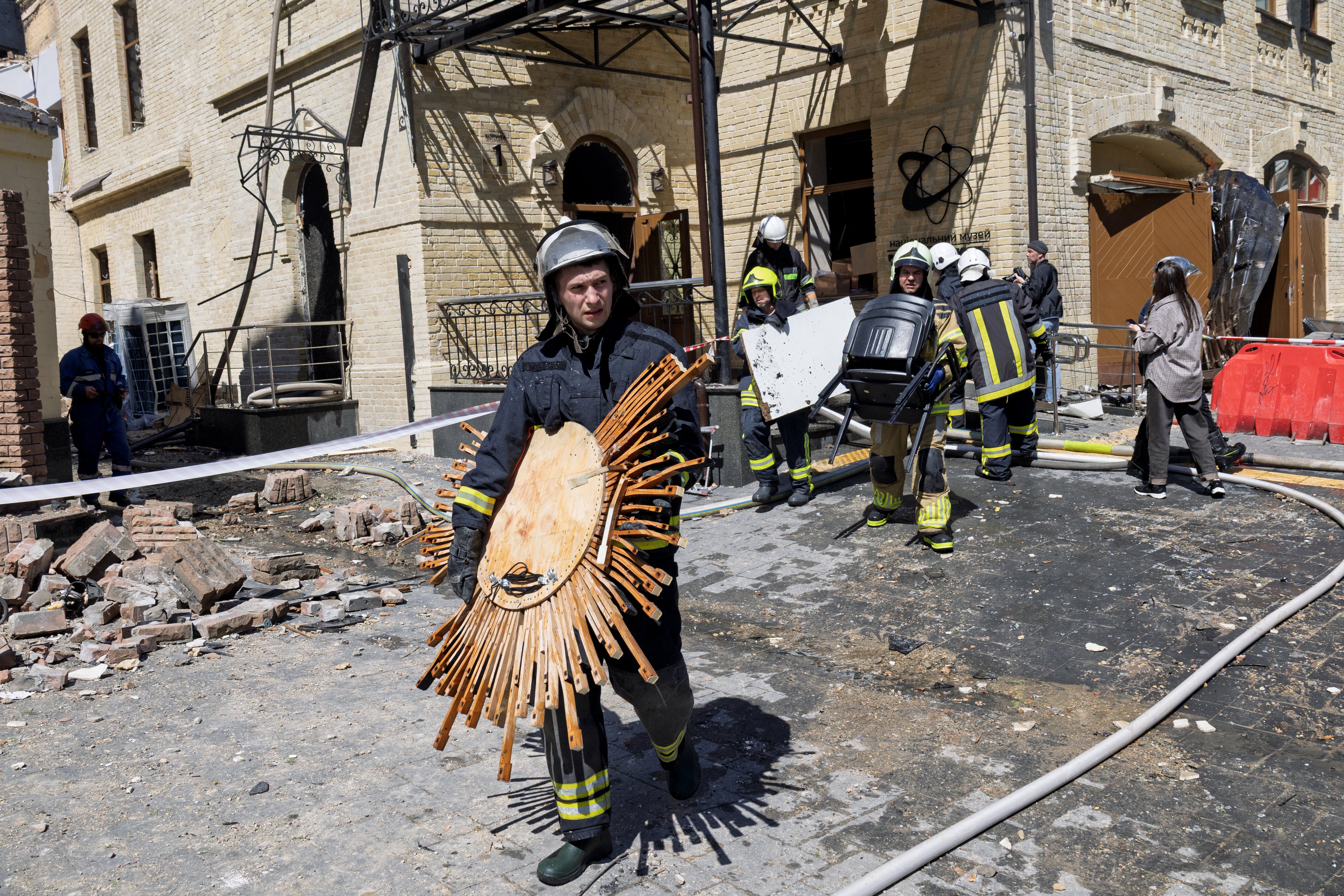 Rescuers and first responders carry out damaged exhibits from the National Chernobyl Museum, heavily damaged by an overnight Russian airstrike, in Kyiv on May 24, 2026, amid the Russian invasion of Ukraine.