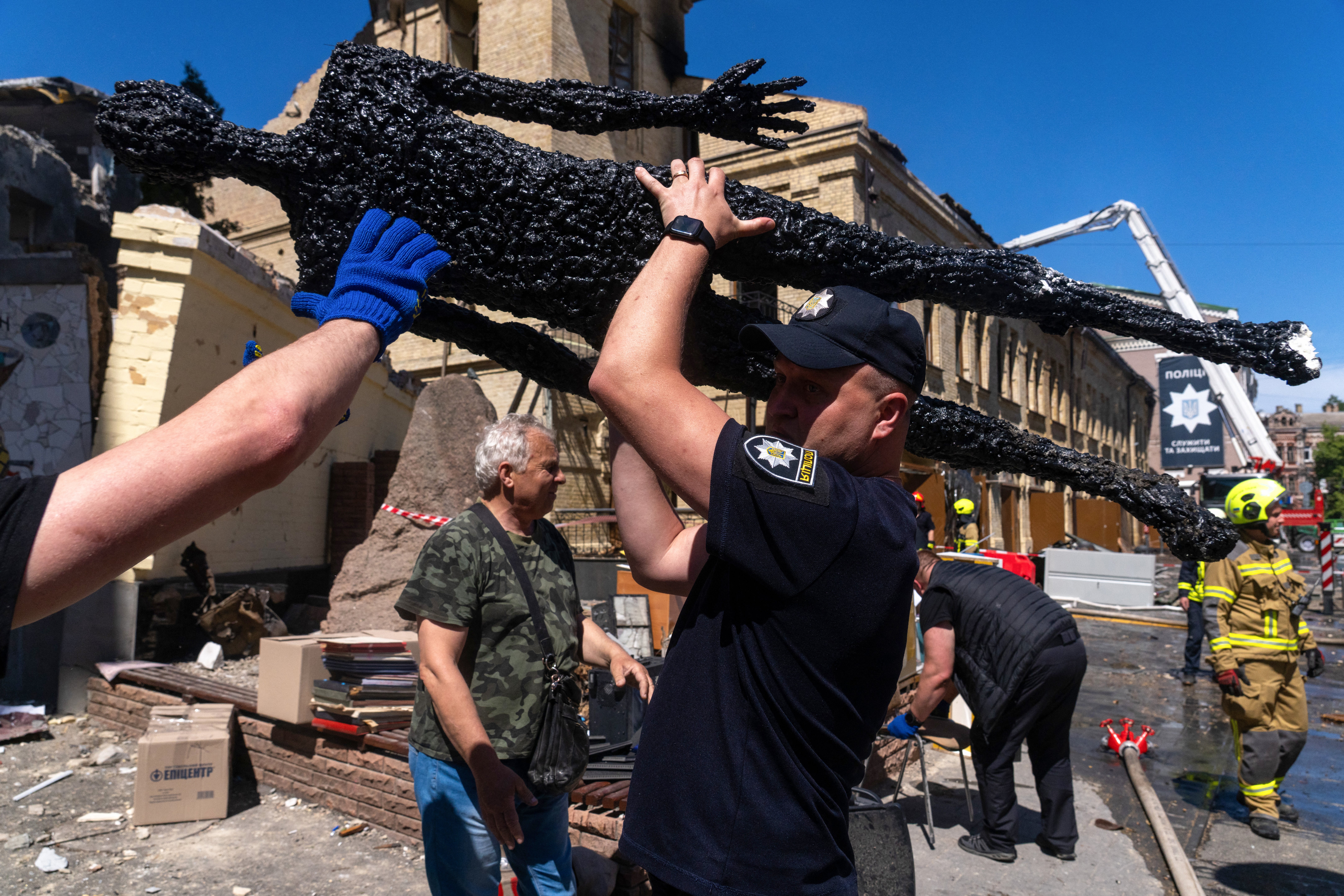 A policeman carries out a damaged exhibit from the National Chernobyl Museum, heavily damaged by an overnight Russian airstrike, in Kyiv