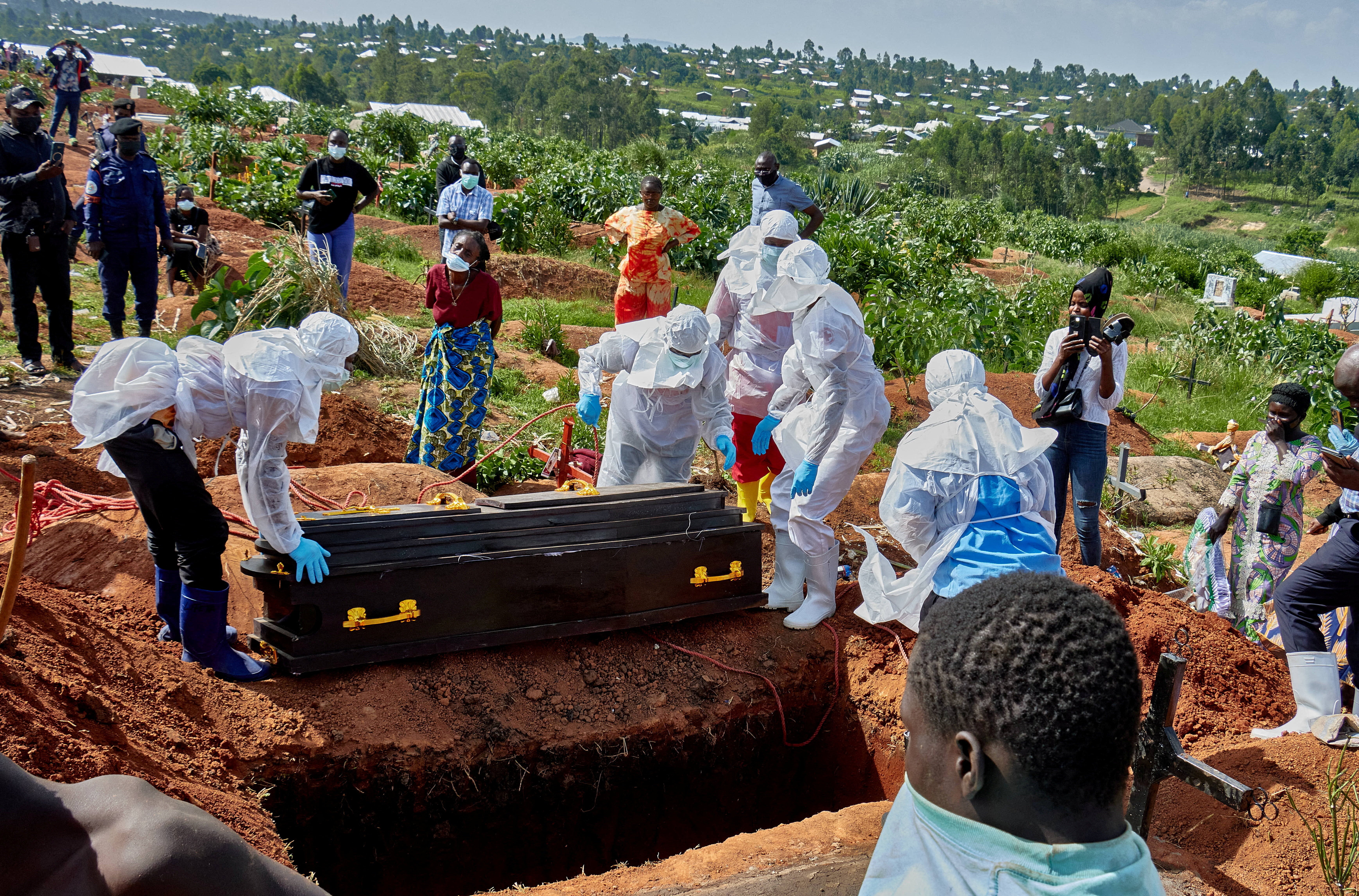 Red Cross workers wearing personal protective equipment (PPE) prepare to lower the coffin of Dr Tibenderana Katho Blaise who worked at the Centre Medical Evangelique (CME) in Hoho commune and died of Ebola virus