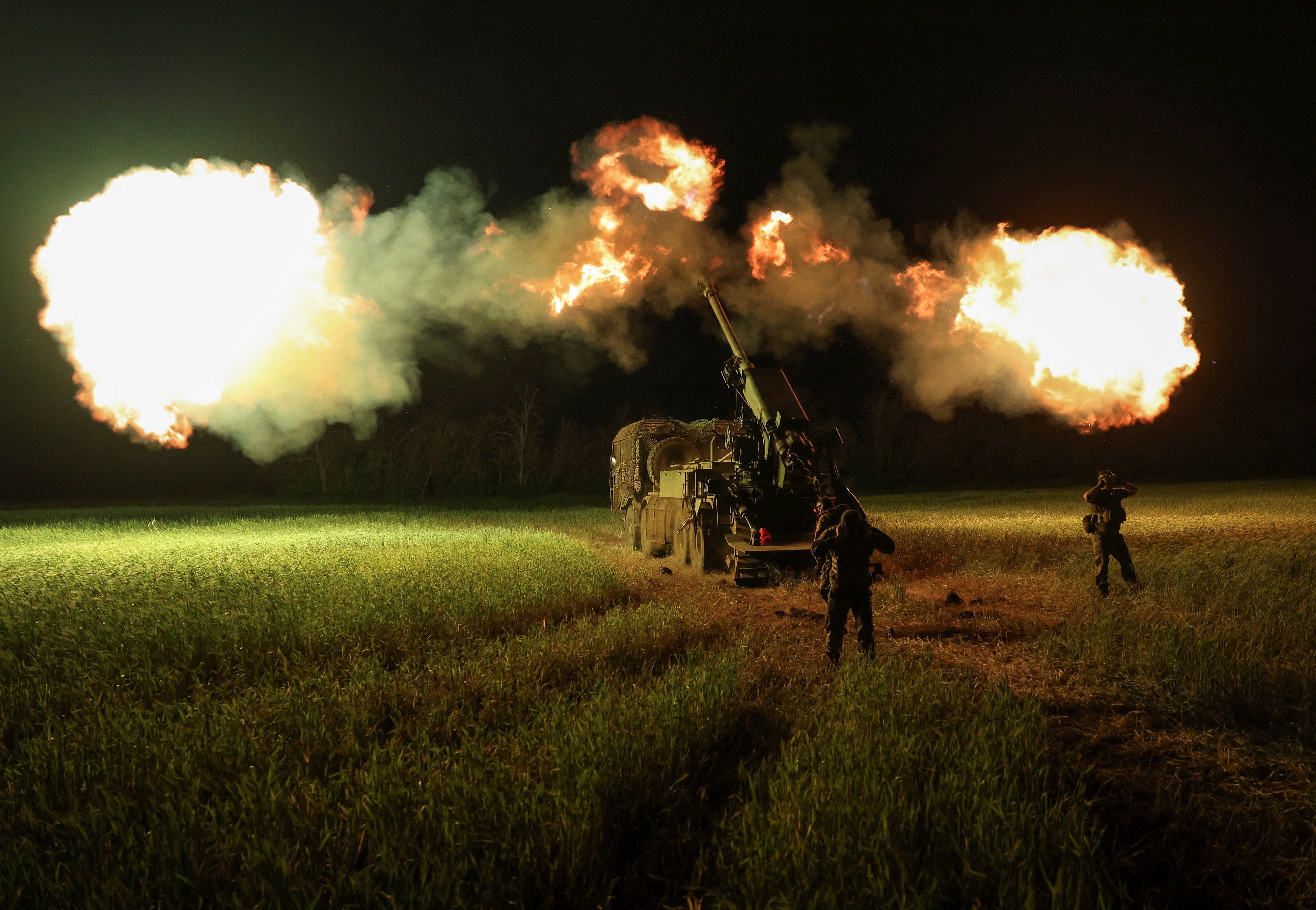 Ukrainian servicemen fire a self-propelled howitzer toward Russian positions (Reuters)