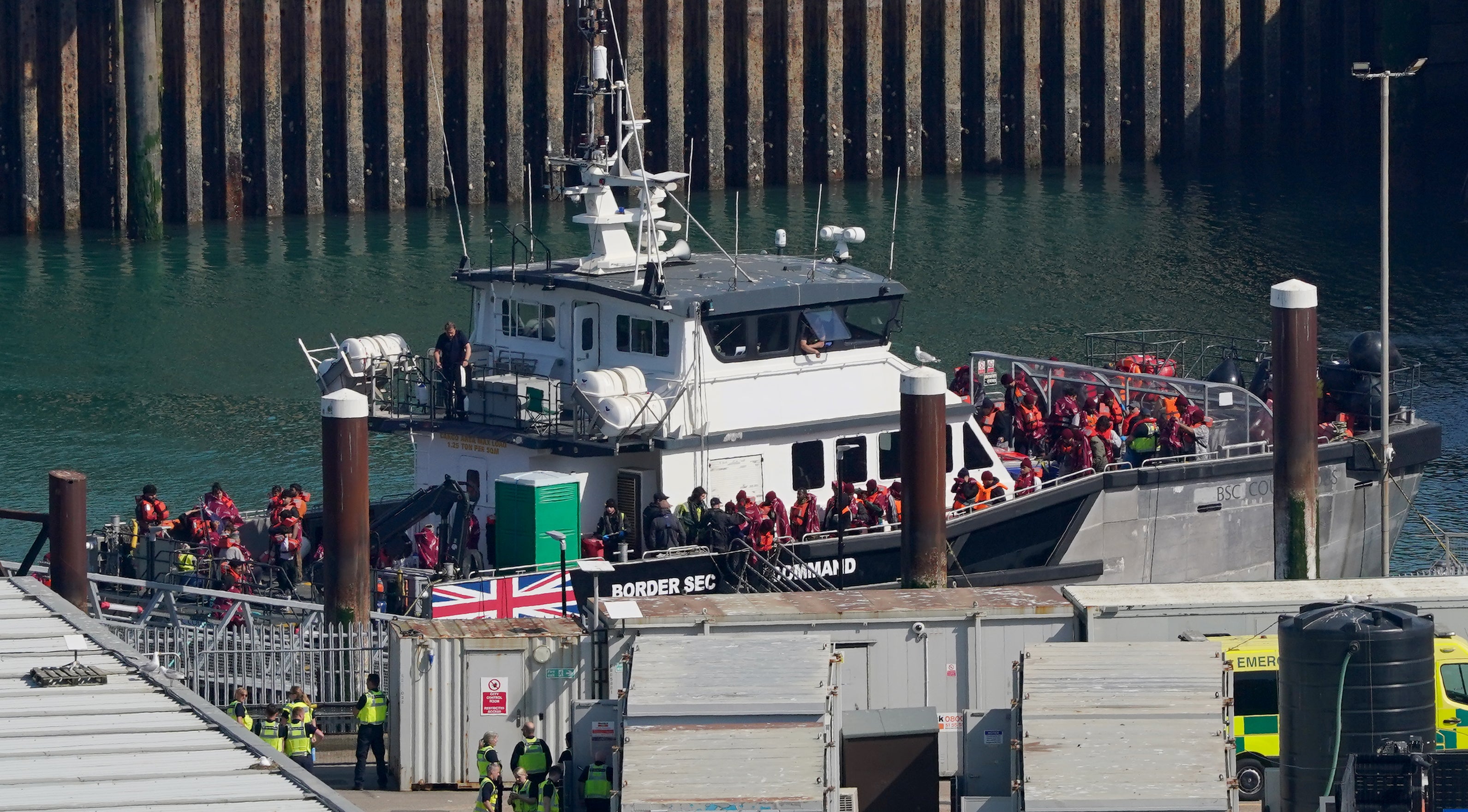 Photos show people disembarking from a Border Security Command boat at Dover, in Kent, on Wednesday, wearing life vests and blankets