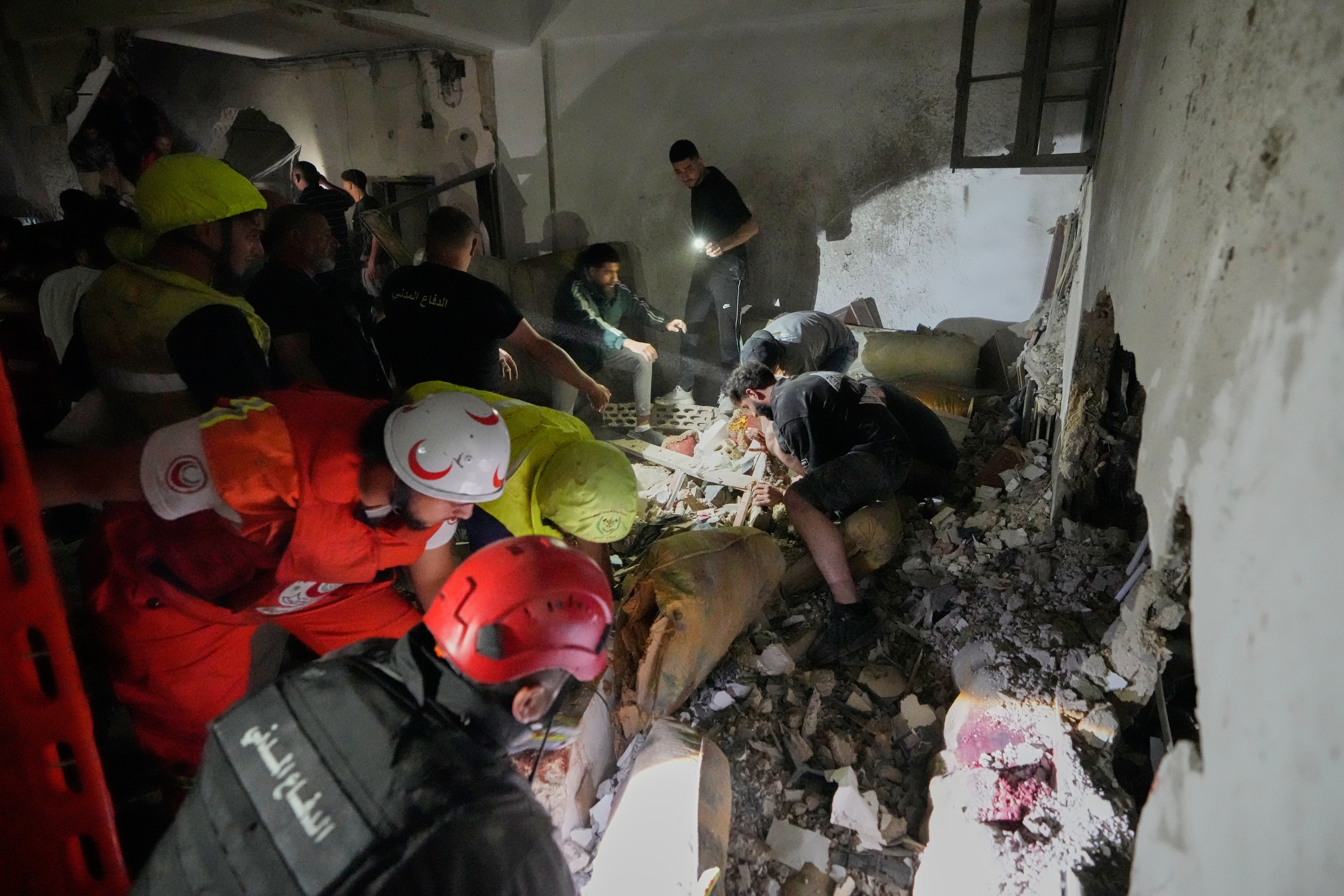 Rescue workers search for victims inside a destroyed apartment that was damaged by an Israeli airstrike in the southern port city of Sidon