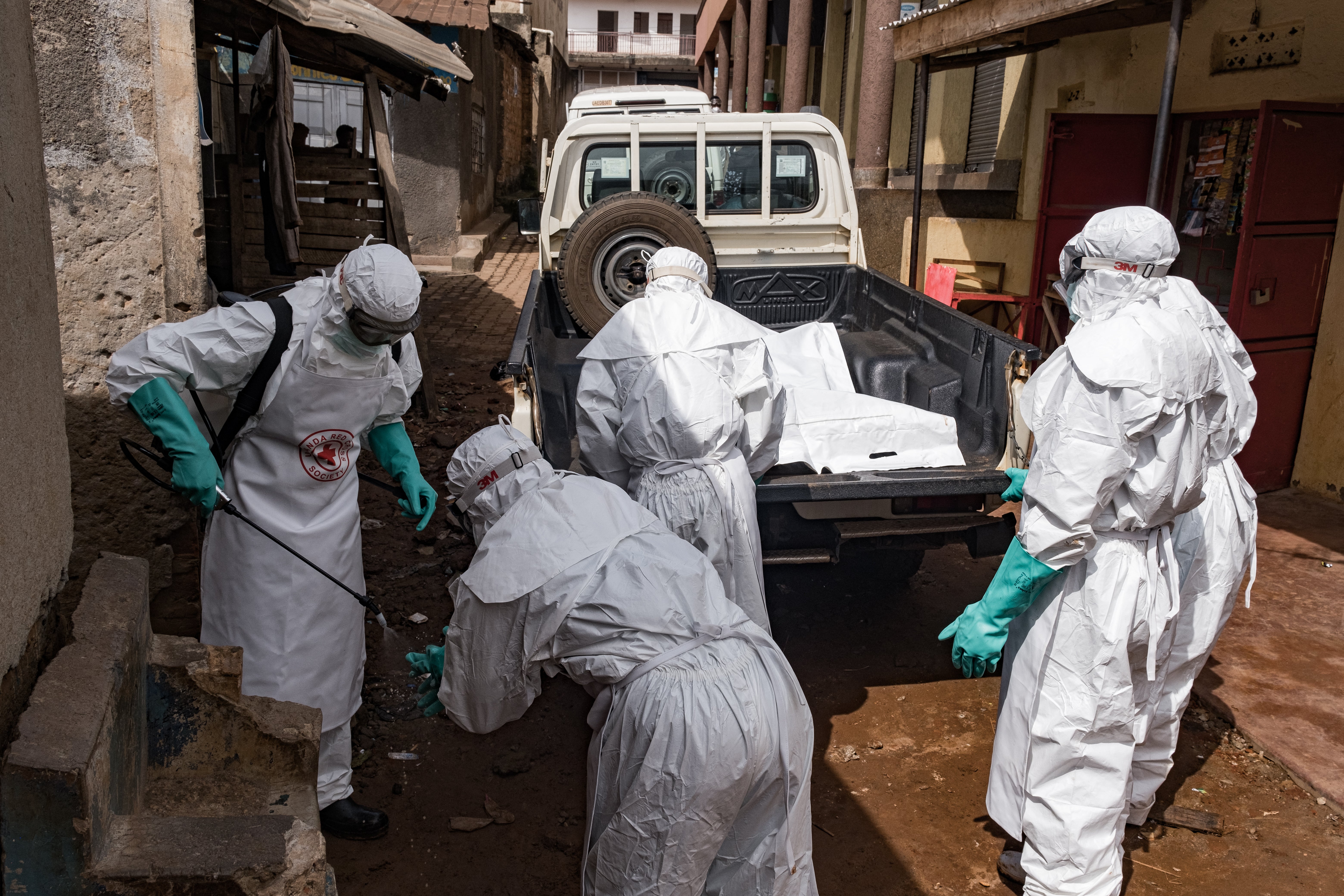 Workers from the Uganda Red Cross Society disinfect during the evacuation of the body of a suspected Ebola victim in Kampala.