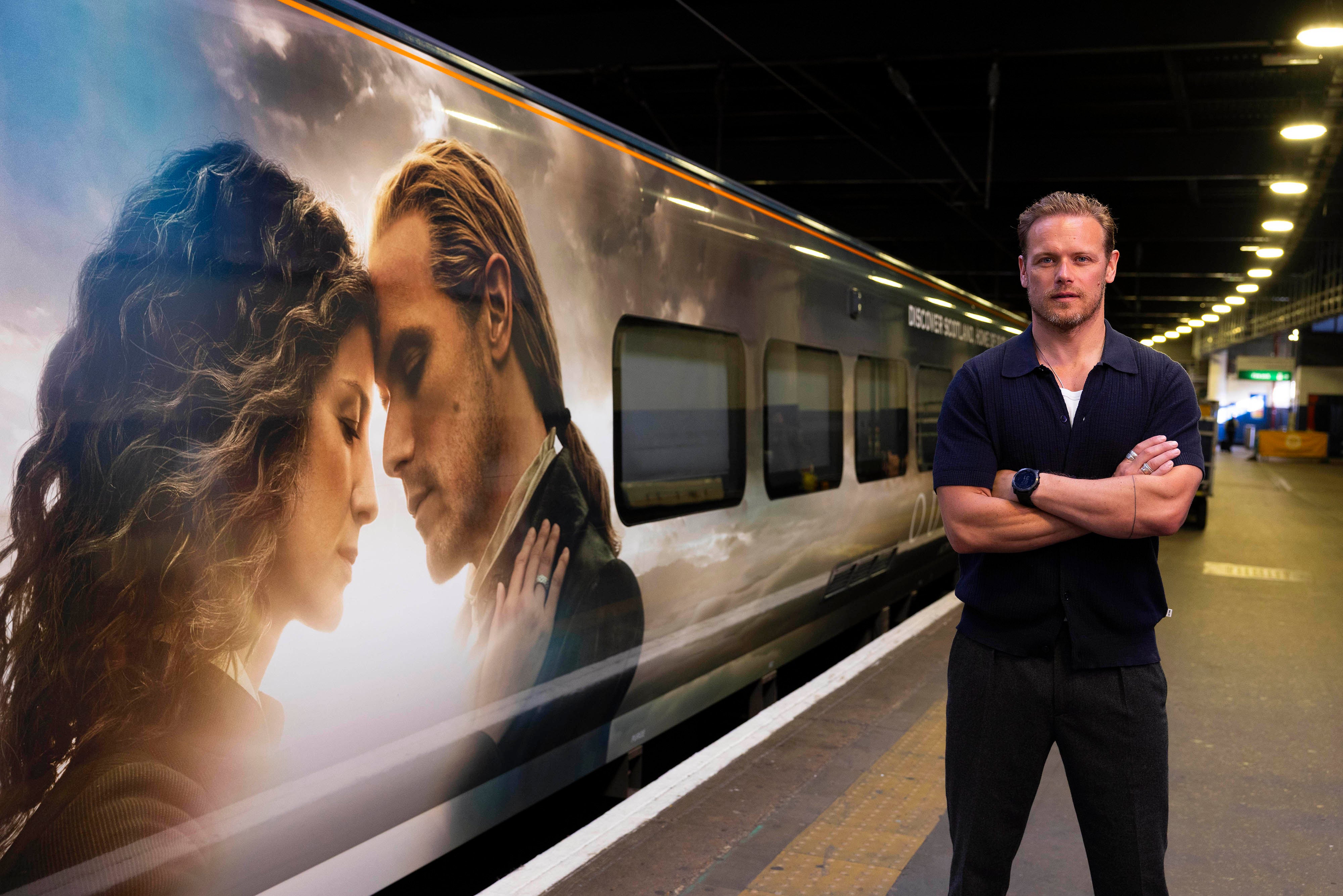 Sam Heughan unveils the Caledonian Sleeper's first full train wrap in London's Euston station, an Outlander-inspired design celebrating the series' connection to Scotland and economic benefit from tourism