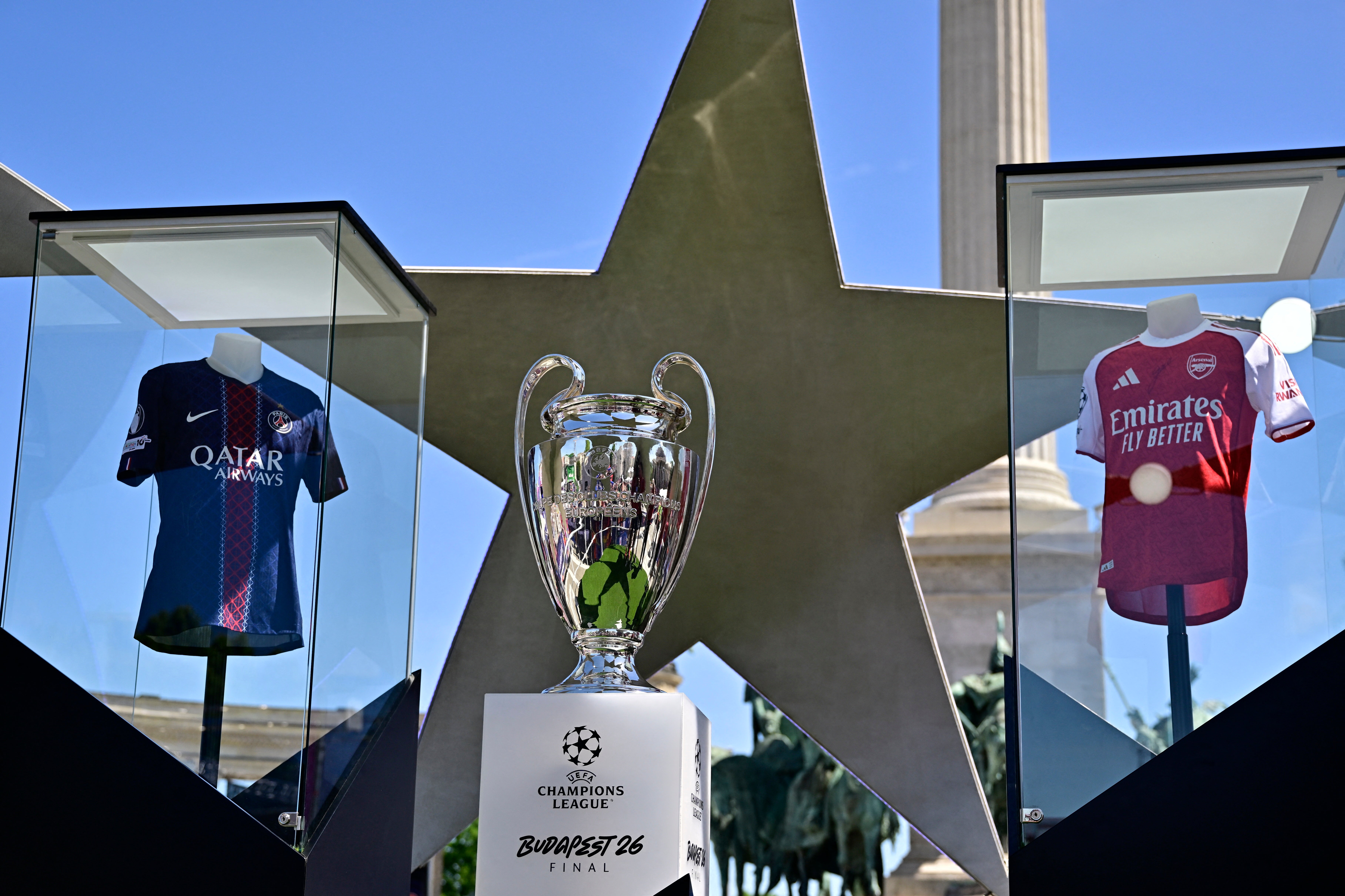 The Uefa Champions League trophy as the shirts of Paris St Germain and Arsenal are kept on display