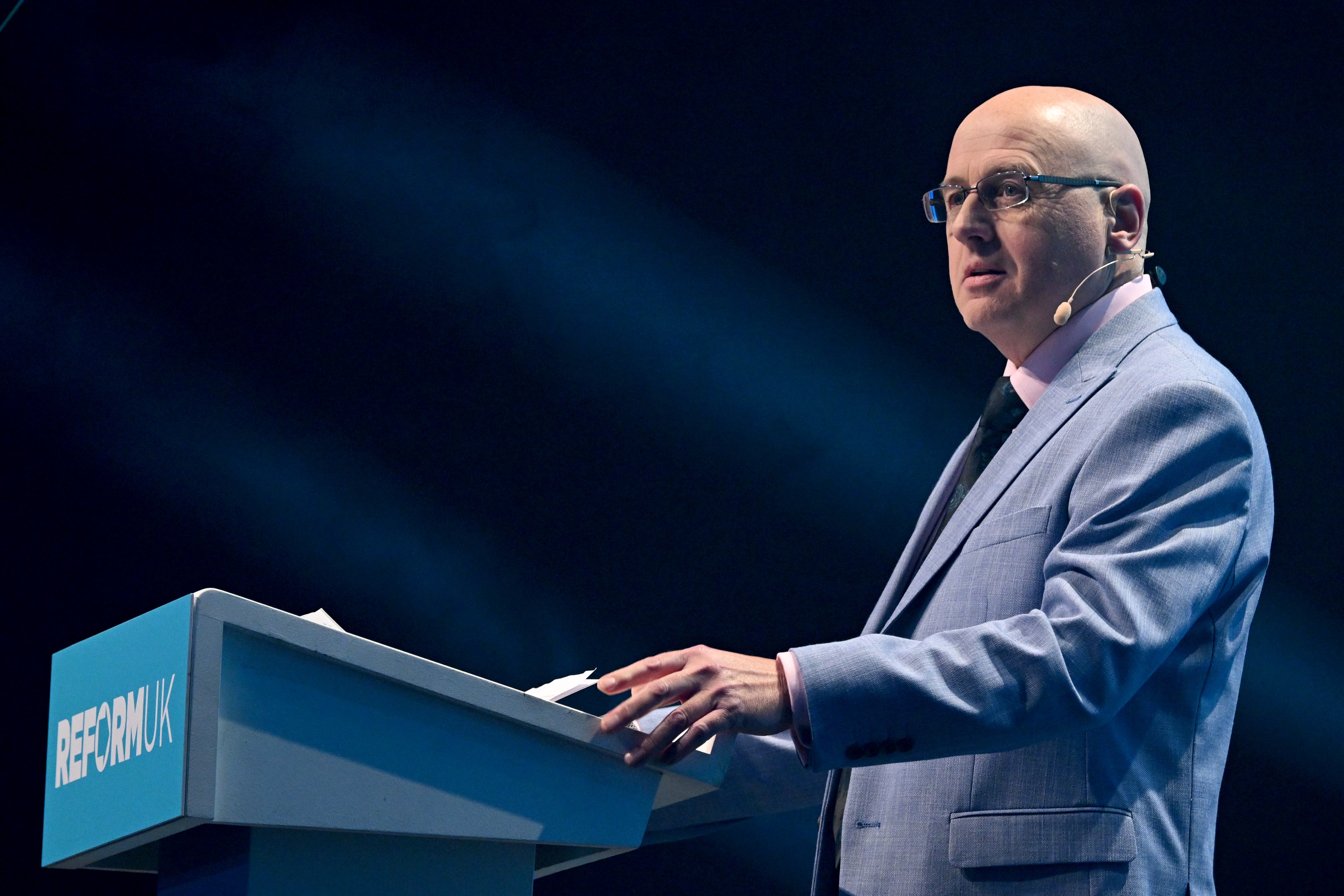 Councilor Keith Prince speaks on stage during the Reform UK rally at Excel London's ICC Auditorium